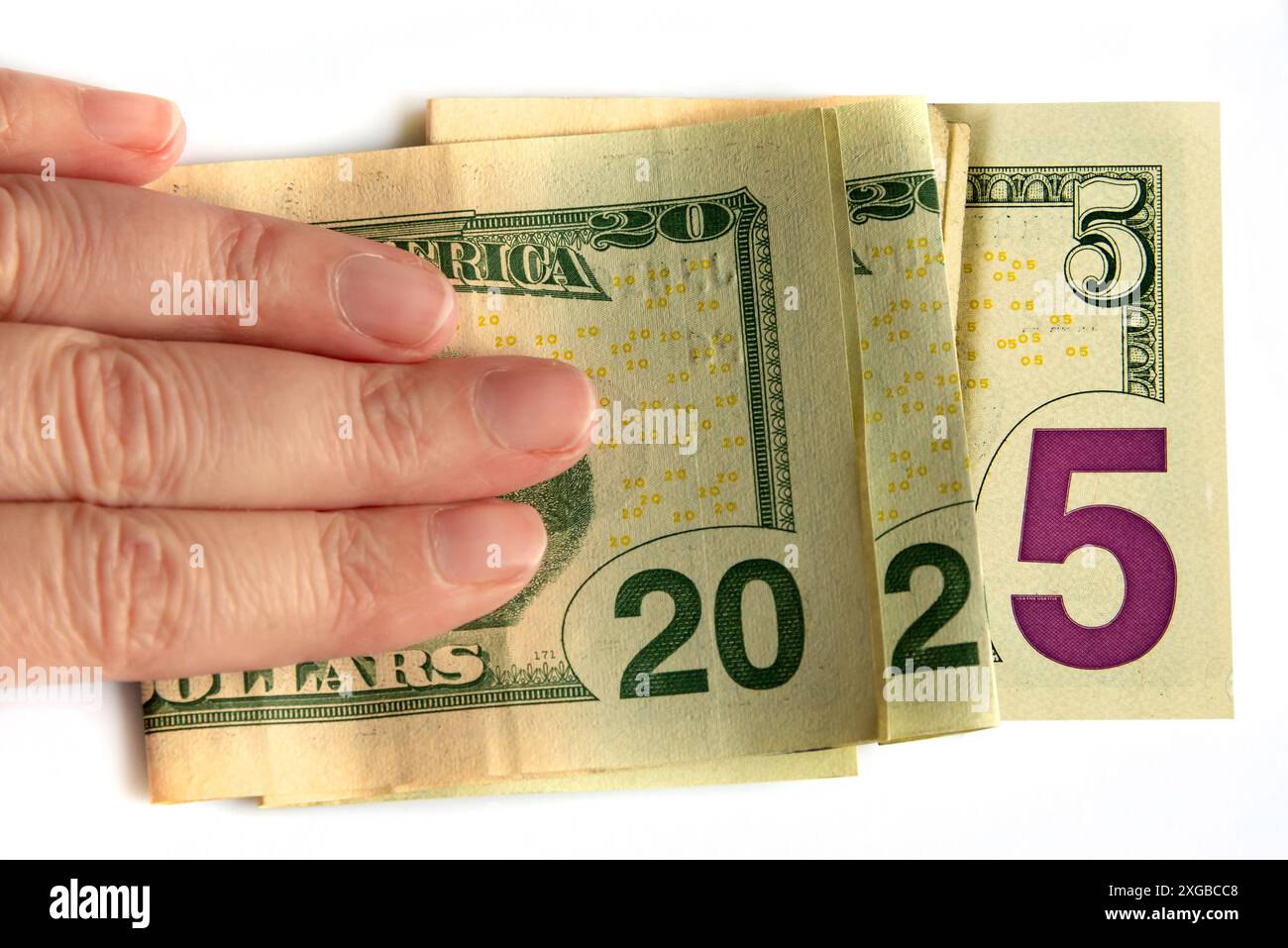 2025 geschrieben mit Dollars Banknoten in einer Hand isoliert auf weißem Hintergrund, Budget und Finanzen Neujahr Money Konzept Stockfoto