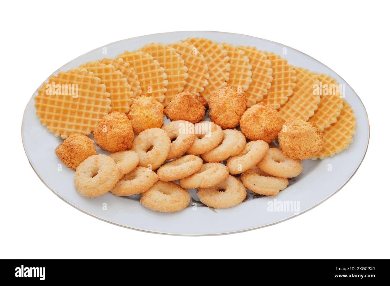 Verschiedene Kuchen und Waffeln in Keramikplatte isoliert auf weißem Hintergrund. Goldener romantischer Keks. Draufsicht. Stockfoto