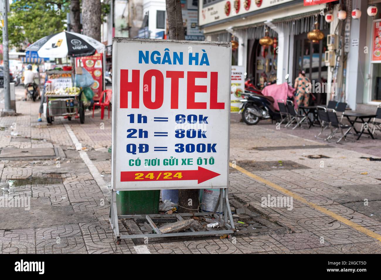 Ho-Chi-Minh-Stadt, Vietnam - 22. Juni 2024: Auf einem Bürgersteig wird ein Hotelschild für Zimmerpreise geworben. Stockfoto