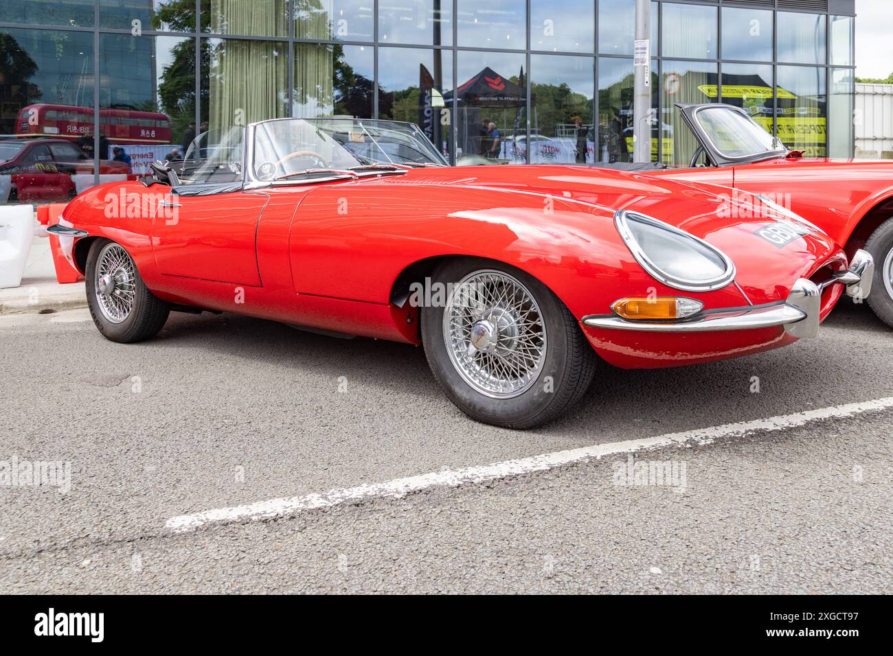 Ein geparkter Jaguar Typ E mit roter Lackierung. Britische Sportwagen oder Konzept der Automobilindustrie. Stockfoto