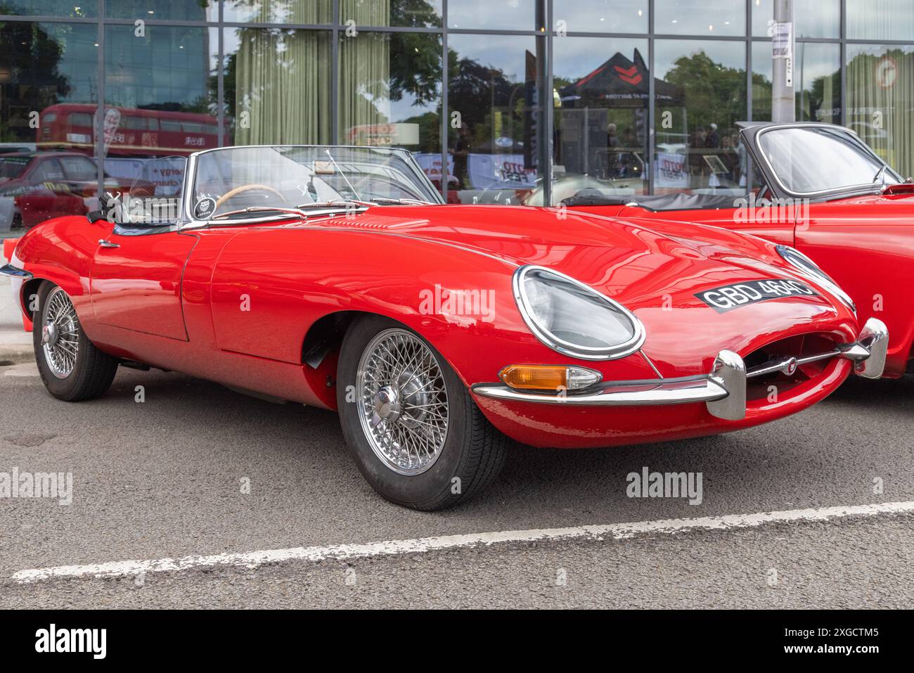 Ein geparkter Jaguar Typ E mit roter Lackierung. Britische Sportwagen oder Konzept der Automobilindustrie. Stockfoto