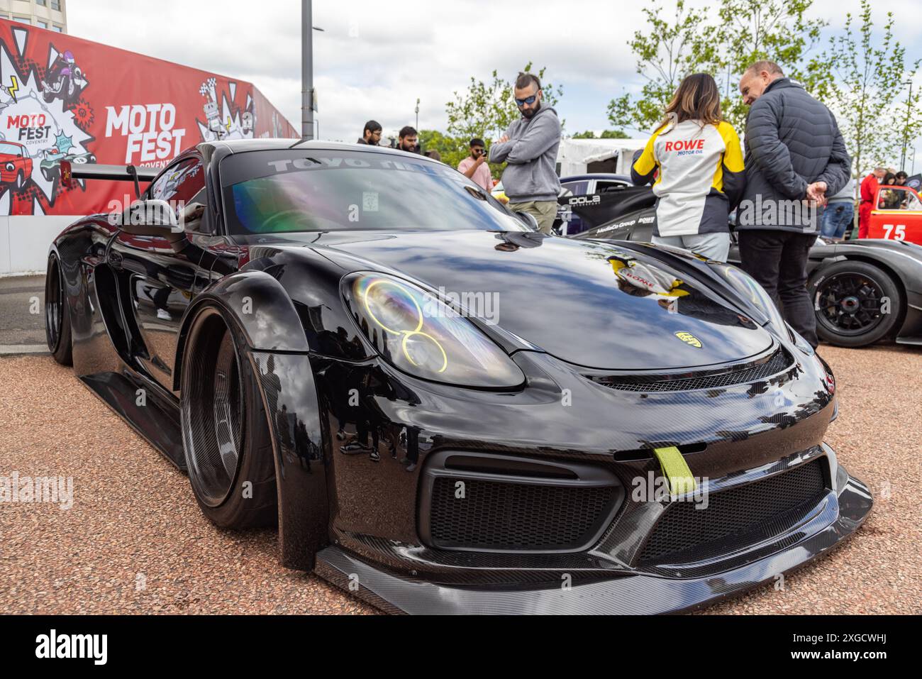 Dreiviertelansicht eines Porsche Cayman mit Karosserie-Styling-Kit, der während des Coventry Motofests in einer urbanen Umgebung geparkt wurde. Stockfoto