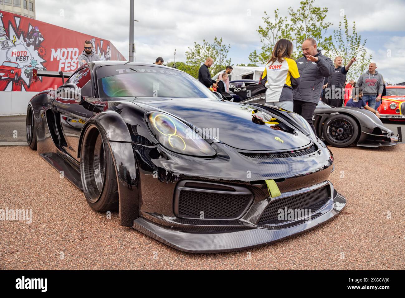 Dreiviertelansicht eines Porsche Cayman mit Karosserie-Styling-Kit, der während des Coventry Motofests in einer urbanen Umgebung geparkt wurde. Stockfoto