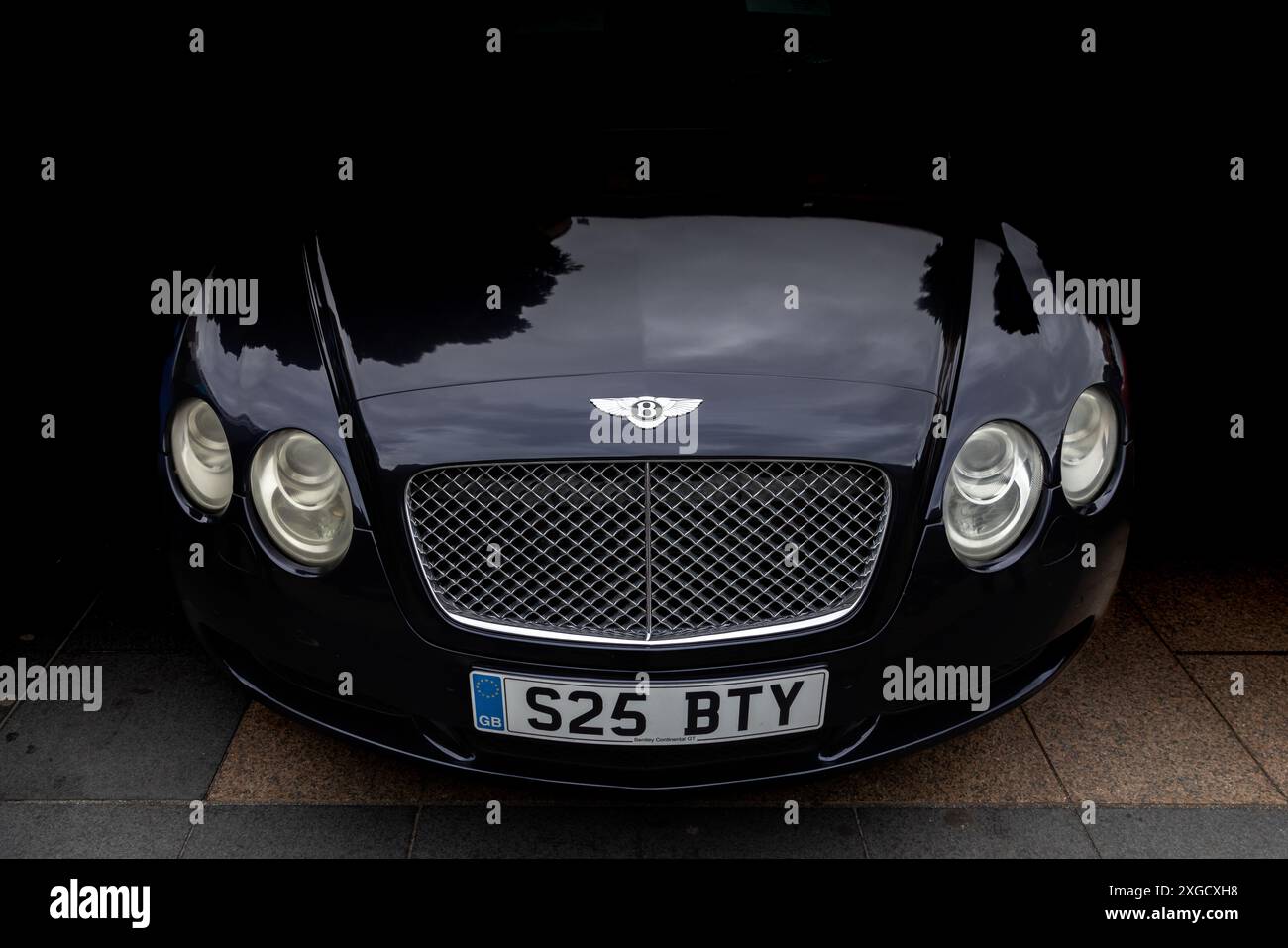 Stimmungsvolle Aufnahme einer Bentley Continental Front mit dem legendären Kühlergrill, den eleganten Scheinwerfern und dem strahlenden Licht. Autofotografie. Stockfoto