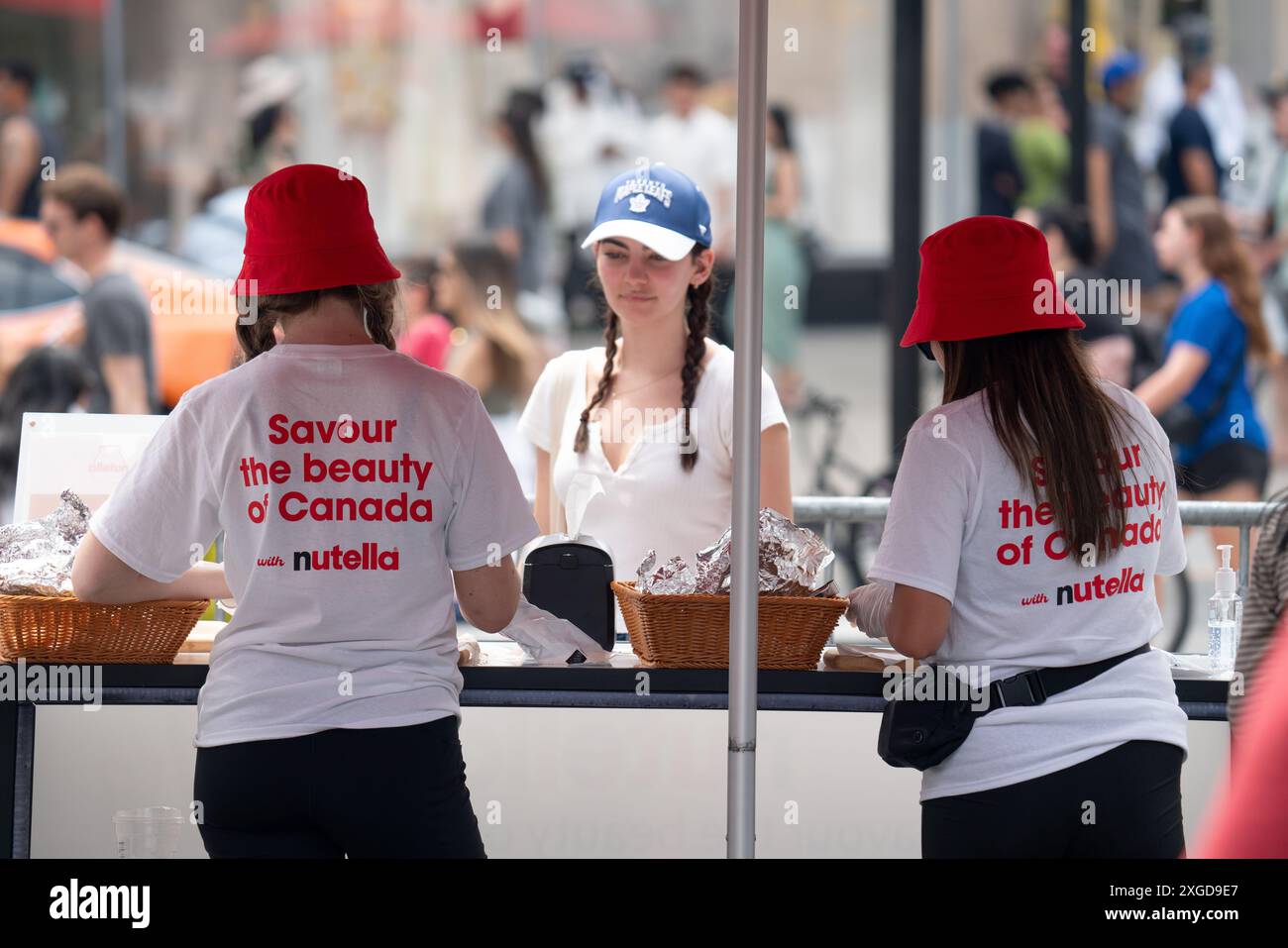 Mitarbeiter von Nutella verteilen kostenlose Proben an Personen, die für eine Marketingveranstaltung im Heißluftballon am Yonge and Dundas Square in Toronto, Kanada, anstehen. Stockfoto