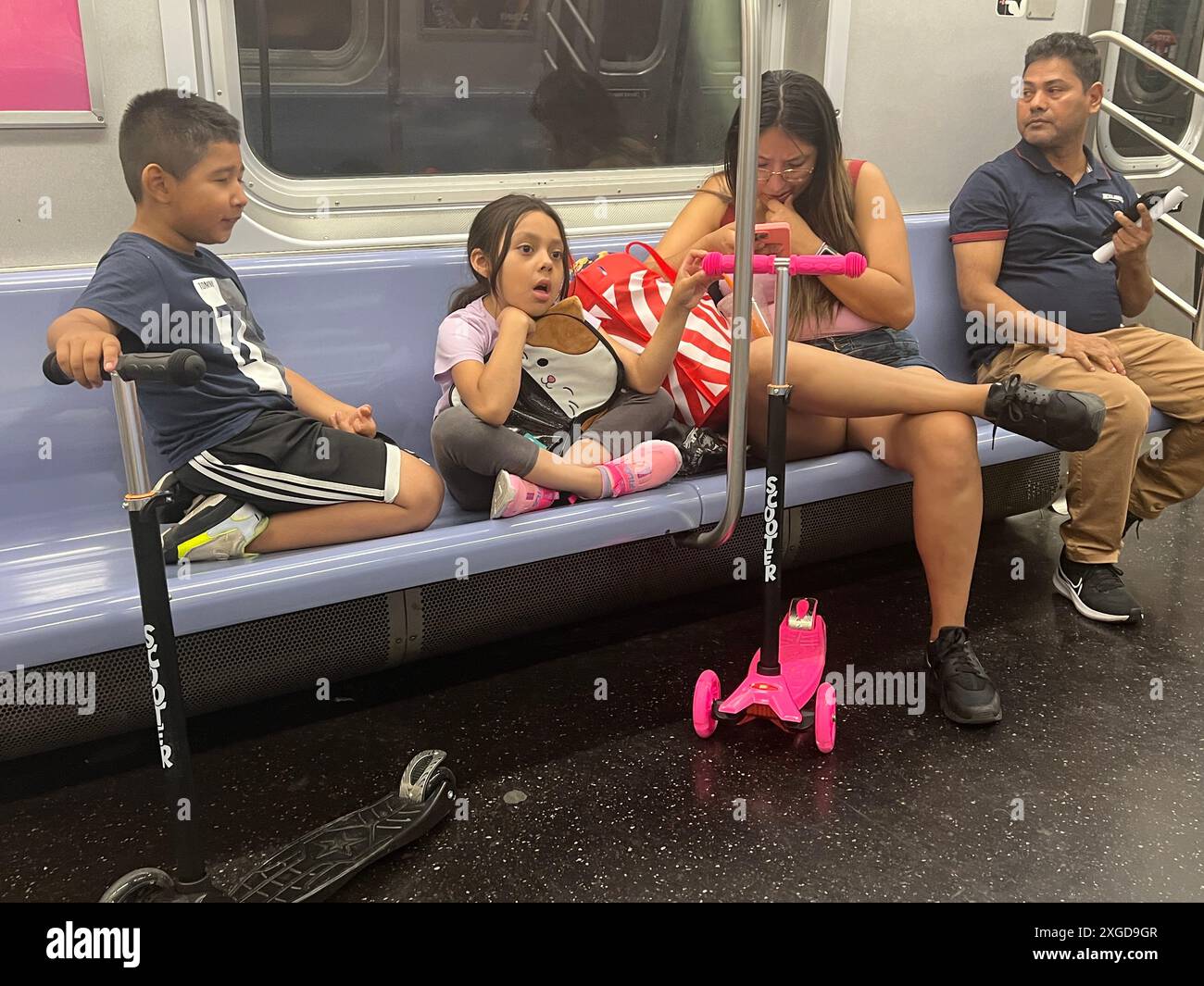 Die Familie hat sich auf einigen Sitzen in einer U-Bahn in New York City ausgebreitet. Stockfoto