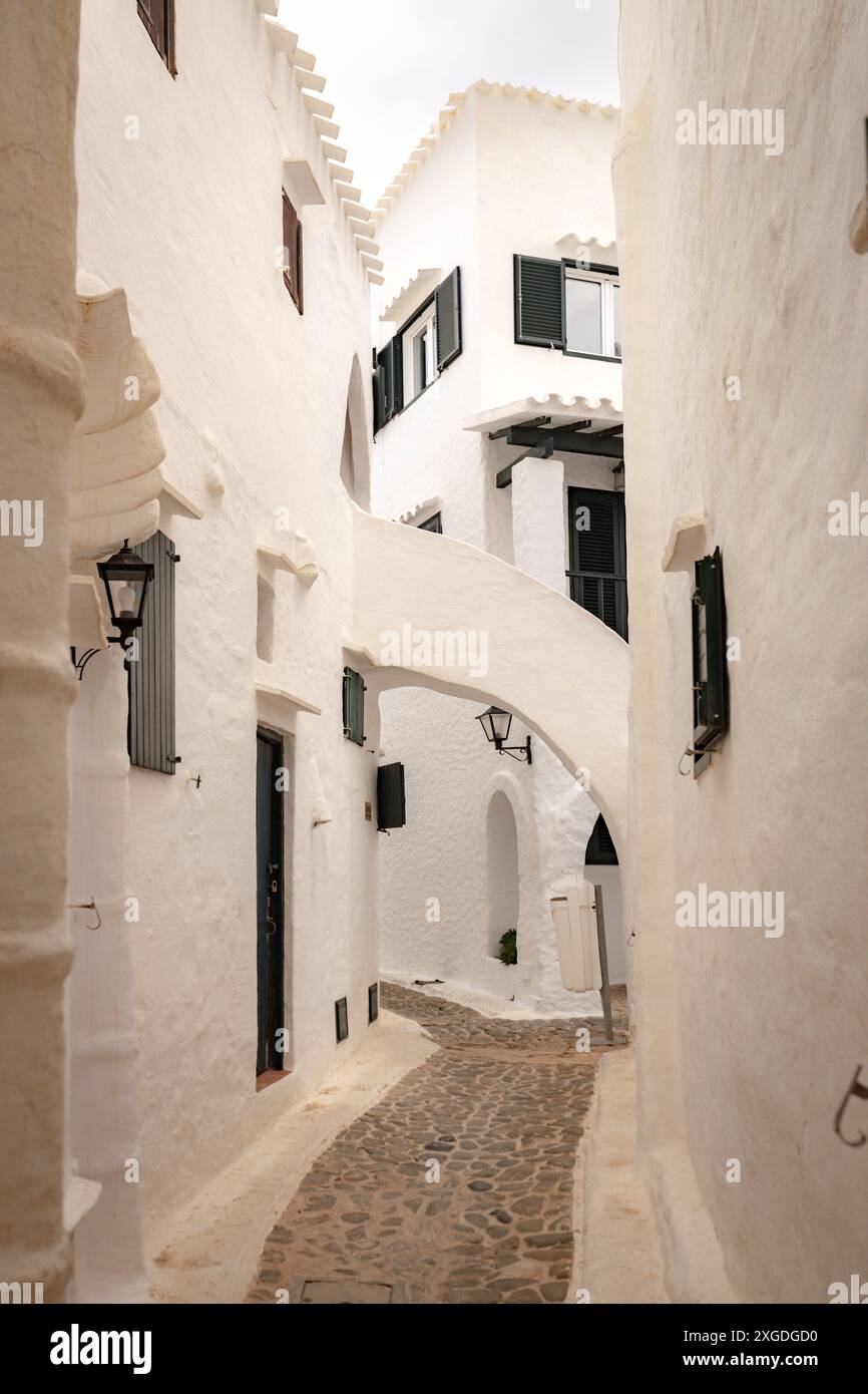 Die wunderschöne Stadt Binibeca auf Menorca. Enge Gassen und weiße Wände von Häusern mit Holzelementen, mediterrane Architektur in Spanien Stockfoto
