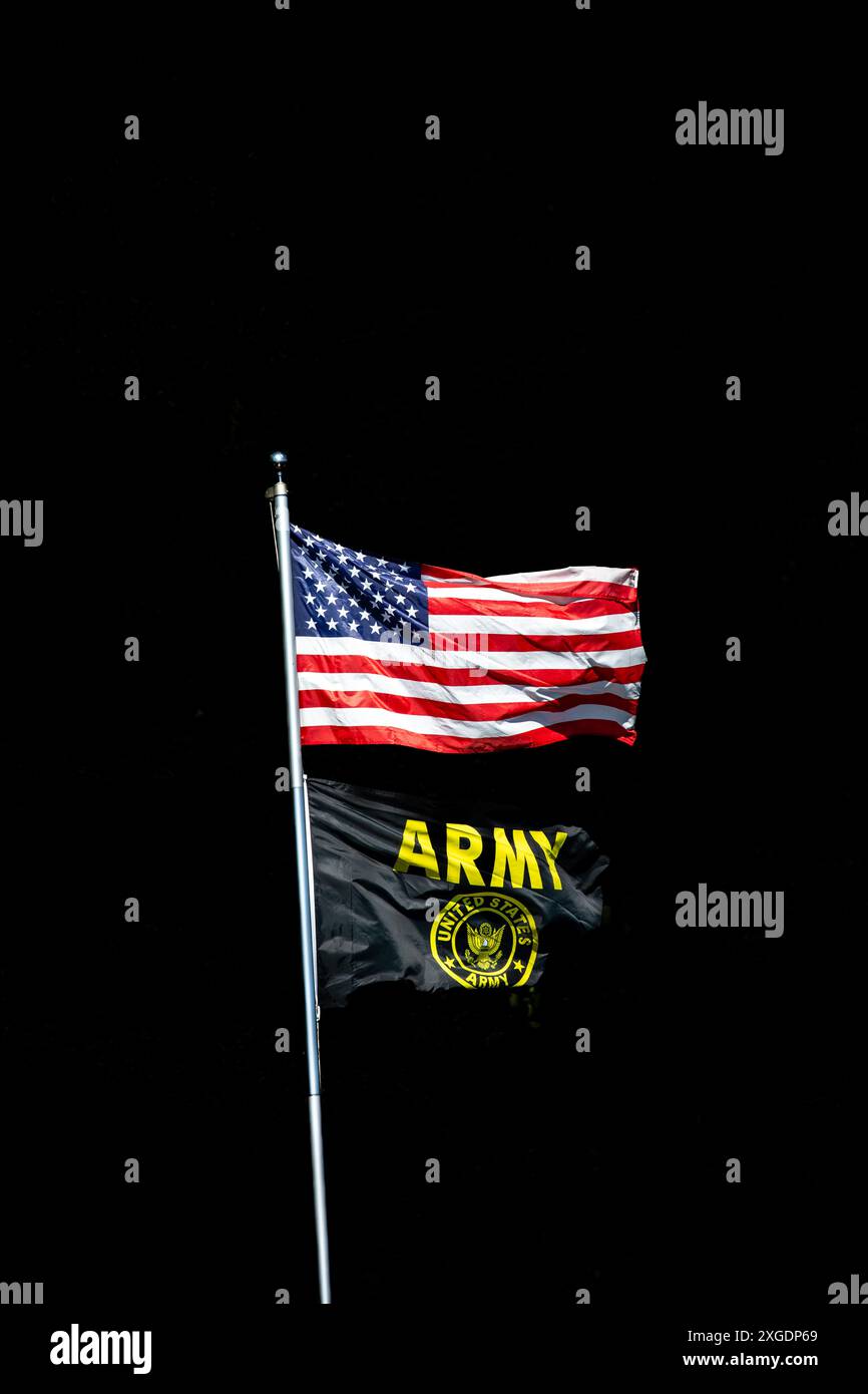 Amerikanische Flagge und Armee-Flagge auf einem Pfosten mit schwarzem Hintergrund und Kopierraum, vertikal Stockfoto Amerikanische Flagge und Armee-Flagge auf einem Pfosten mit schwarzem Hintergrund und Kopierraum, vertikal Stockfoto