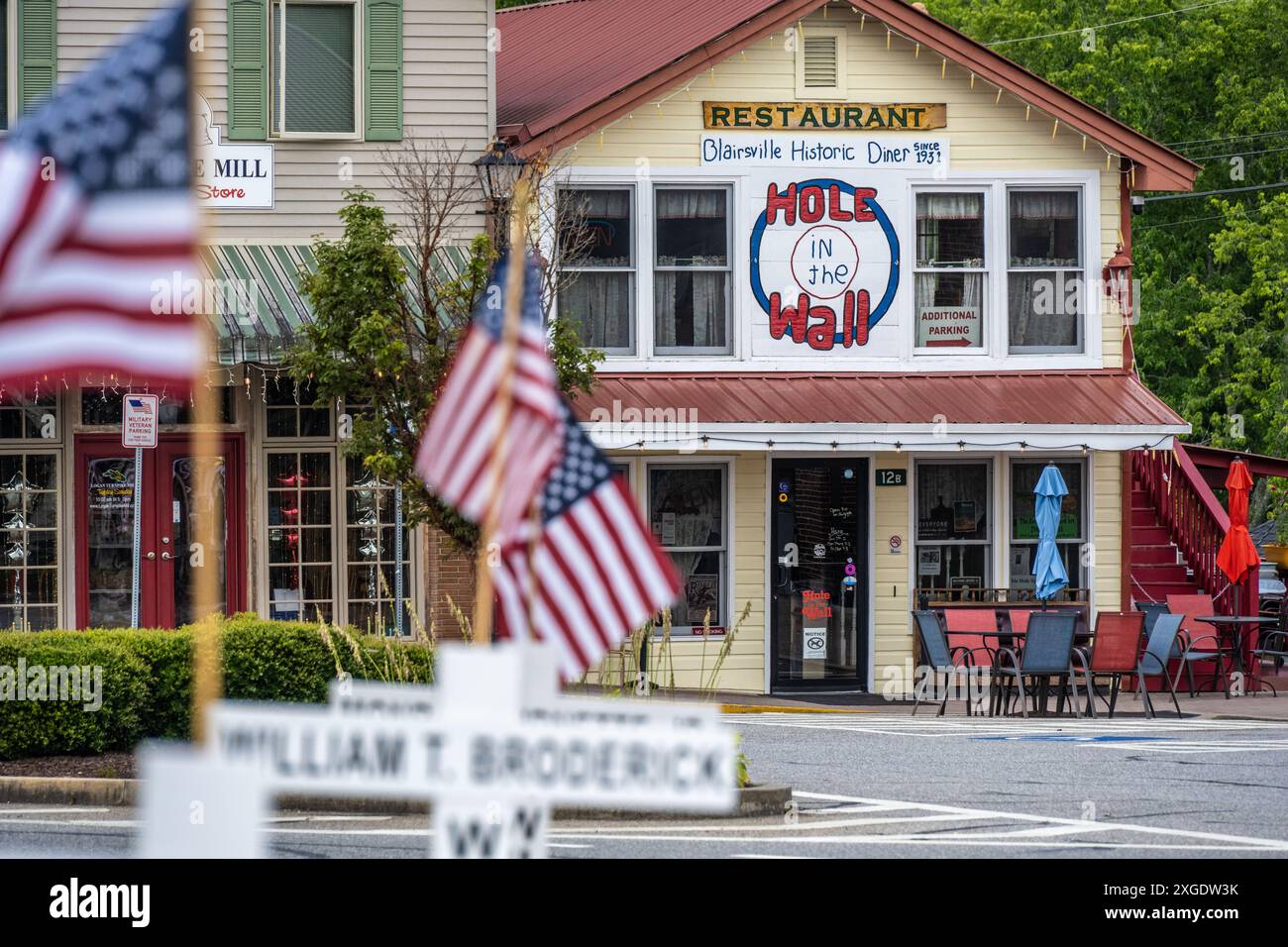 Loch in the Wall Diner, gegründet 1931, auf dem Stadtplatz mit alten Gedenkflaggen in Blairsville, Georgia. (USA) Stockfoto