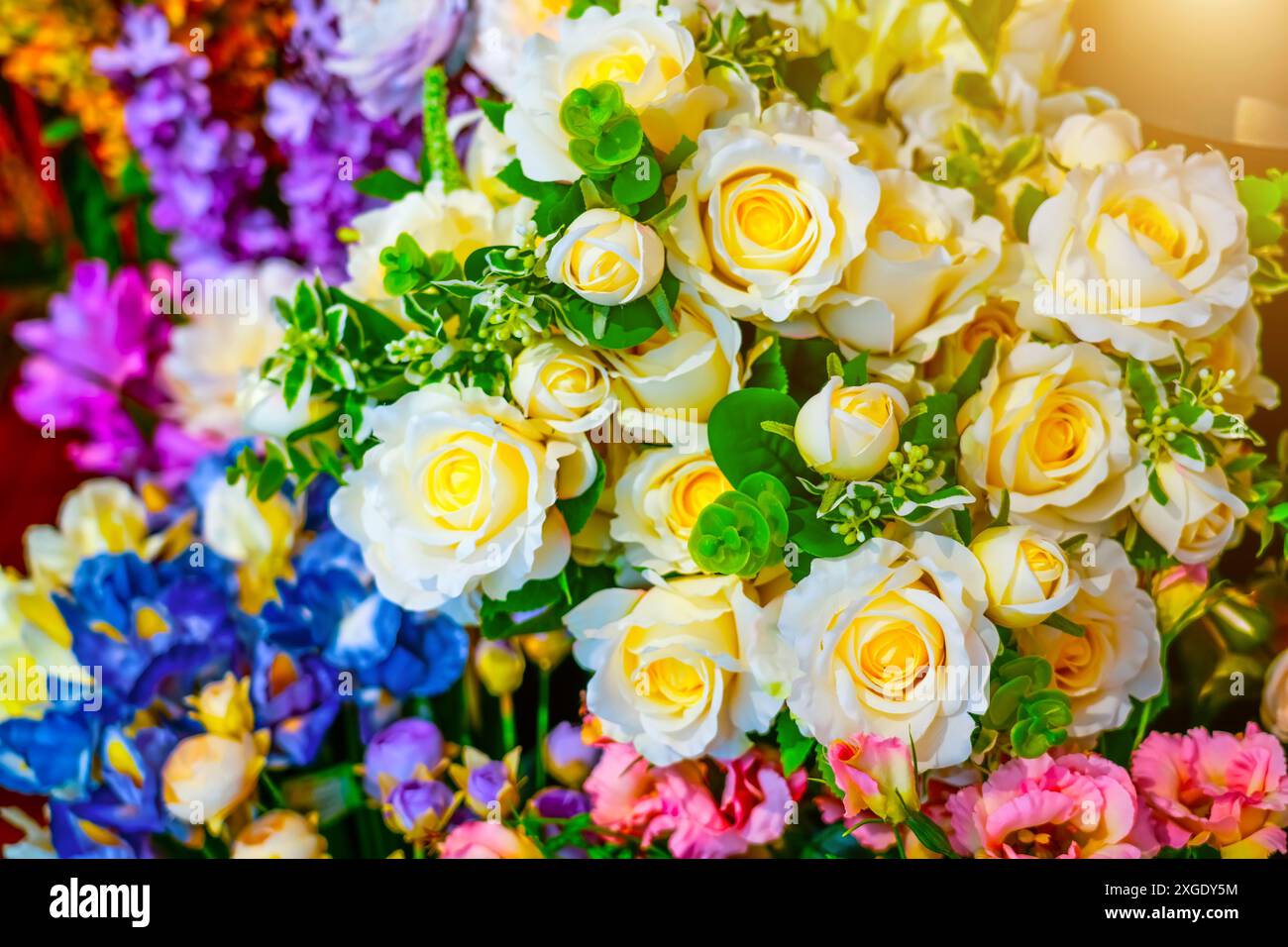 Zusammensetzung aus scharlachrosa Rosen Kunstblumen aus hochwertigem Kunststoff, imitiert natürliche echte Tarnung. Stockfoto