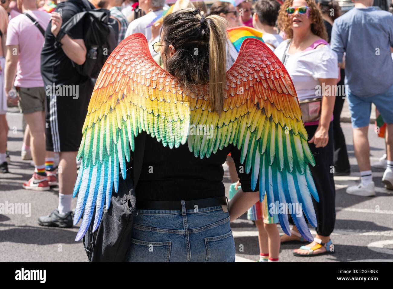 Person mit Regenbogenengelsflügeln - ein Symbol für die Schönheit, Vielfalt und Widerstandsfähigkeit der LGBTQ+ Community - im London Pride 2024, England Stockfoto