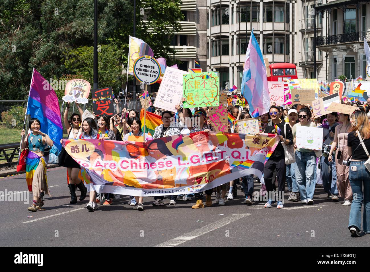 Eine Gruppe Chinesen, die auf London Pride 2024 marschieren, mit einem großen Banner mit der Aufschrift „We are Chinese L.G.B.T.Q.I.A.+“ und mit Mandarin-Schildern Stockfoto