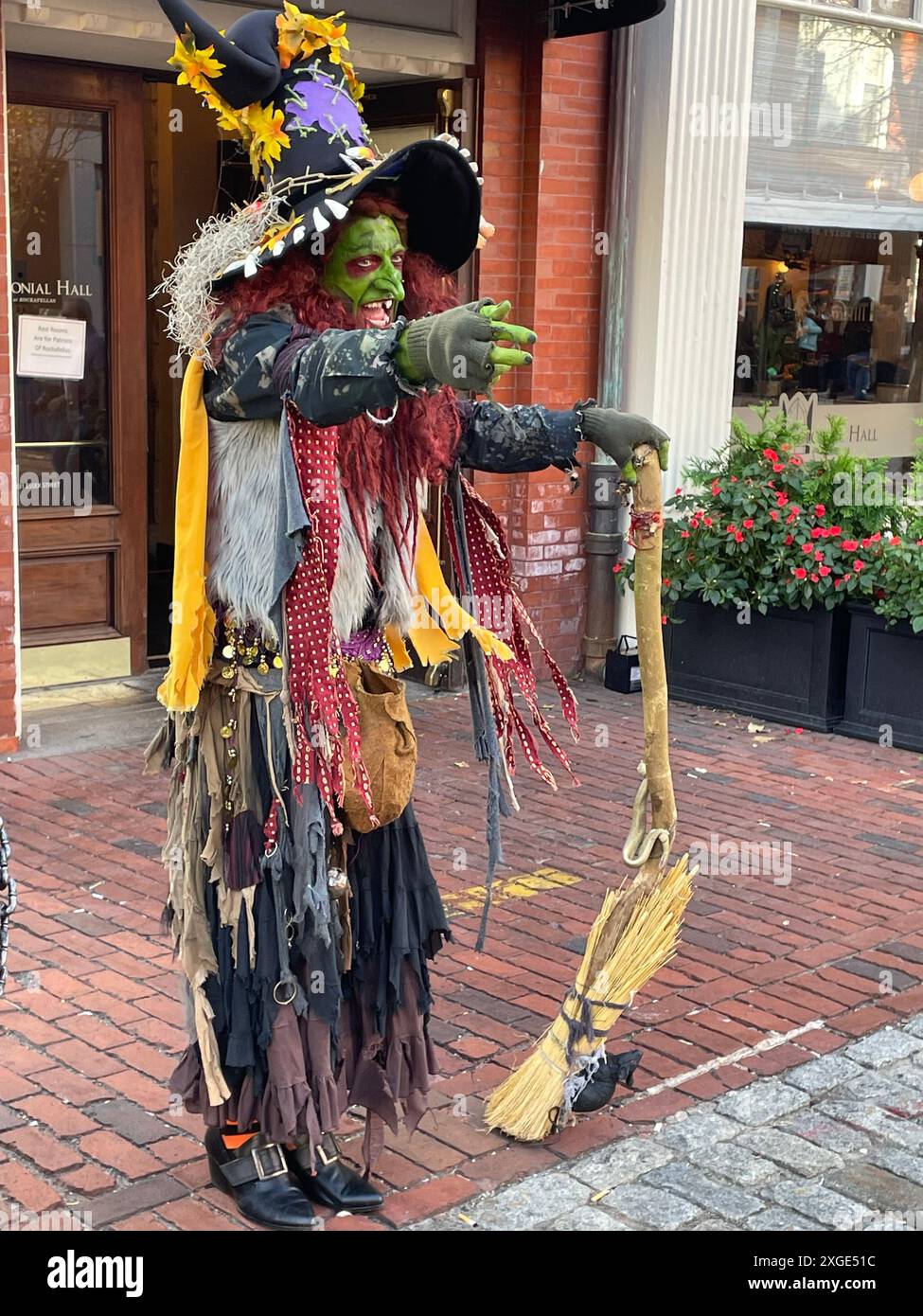 Eine Person in Hexenkostüm und grünem Make-up unterhält Besucher auf einem Halloween-Festival in Salem Massachusetts Stockfoto