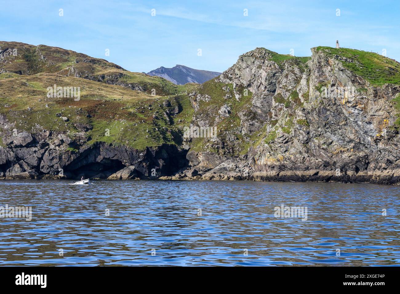 Irischer Küstenfischer kleines Küstenboot, das entlang der felsigen Küste in der Nähe von Teelin County Donegal Irland segelt. Küstenlandschaft Irland. Stockfoto