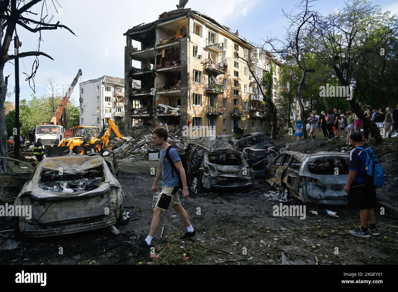 Kiew, Ukraine. Juli 2024. Die Menschen betrachten die verbrannten Autos, die in der Nähe des zerstörten Wohngebäudes stehen, als Folge eines Raketenangriffs der russischen Armee in Kiew. Als Folge des Raketenangriffs der russischen Armee auf das Gebiet der Ukraine wurden 36 Menschen getötet und 140 verletzt. Quelle: SOPA Images Limited/Alamy Live News Stockfoto