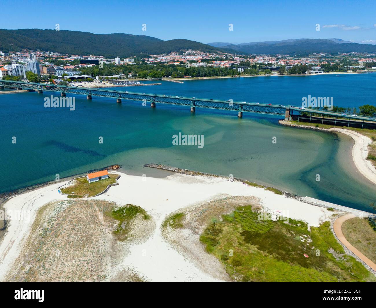 Blick auf eine Küstenstadt mit einer Brücke über einen Fluss, der in das Meer fließt, umgeben von Hügeln und weißem Sandstrand, Blick aus der Luft, Ponte Eiffel Stockfoto