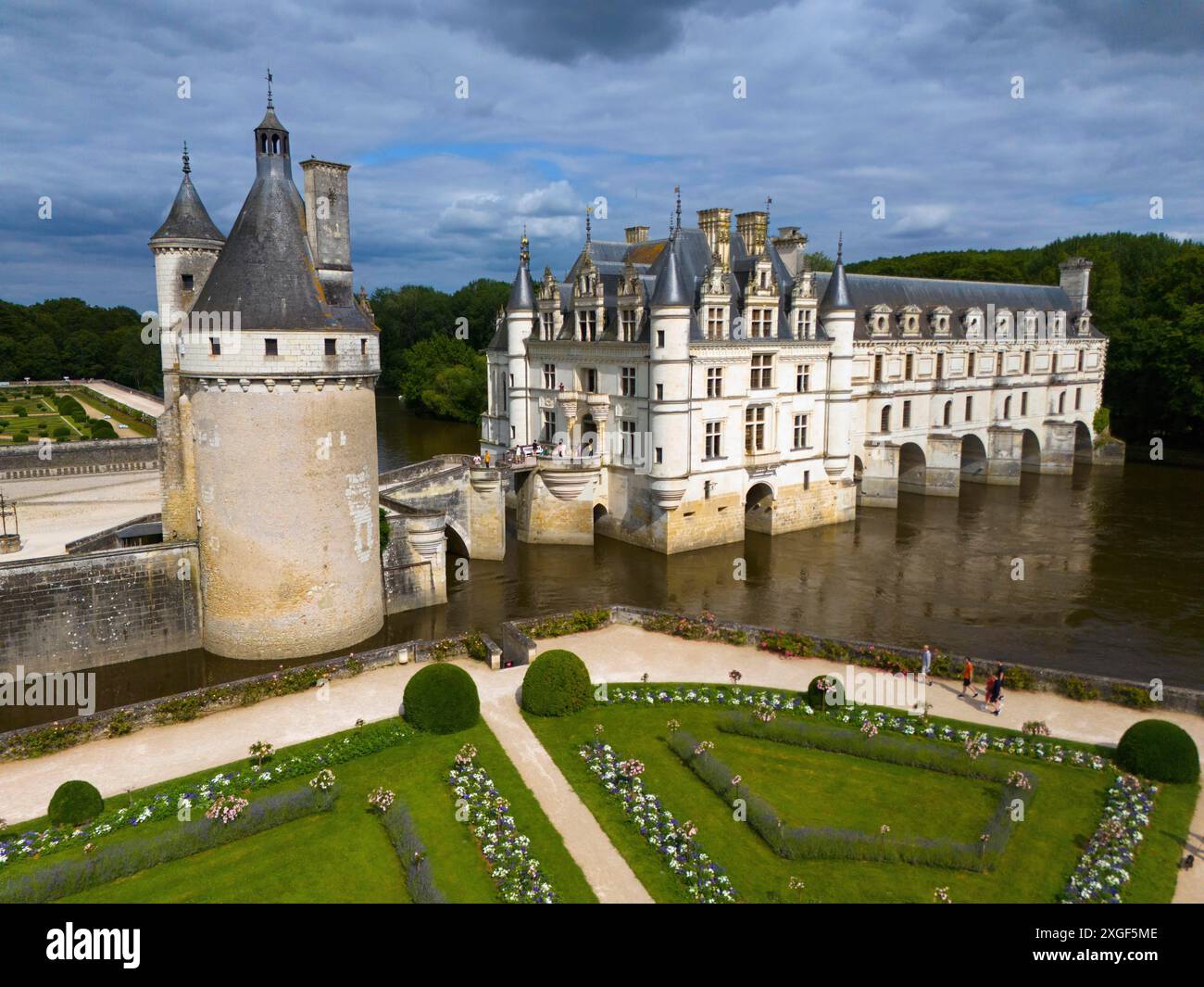 Frontansicht auf ein imposantes Schloss am Fluss Cher mit gepflegten Gärten und dramatischem bewölktem Himmel, aus der Vogelperspektive, Schloss Chenonceau, Schloss de Chateau Stockfoto