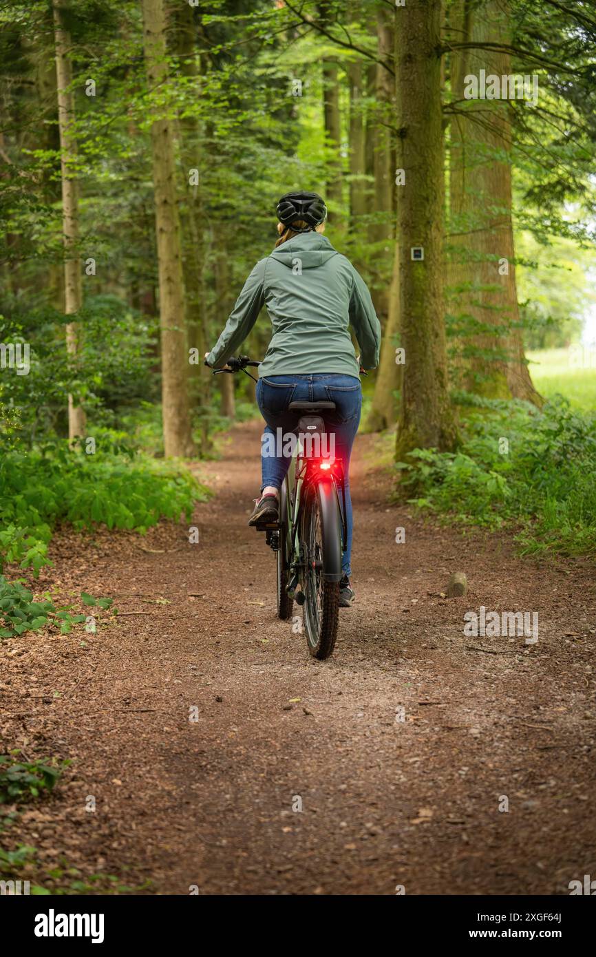 Person, die im Wald Fahrrad fährt. Die Umgebung ist grün und ruhig, mit einem Naturweg, Bad Teinach, Schwarzwald, Deutschland Stockfoto