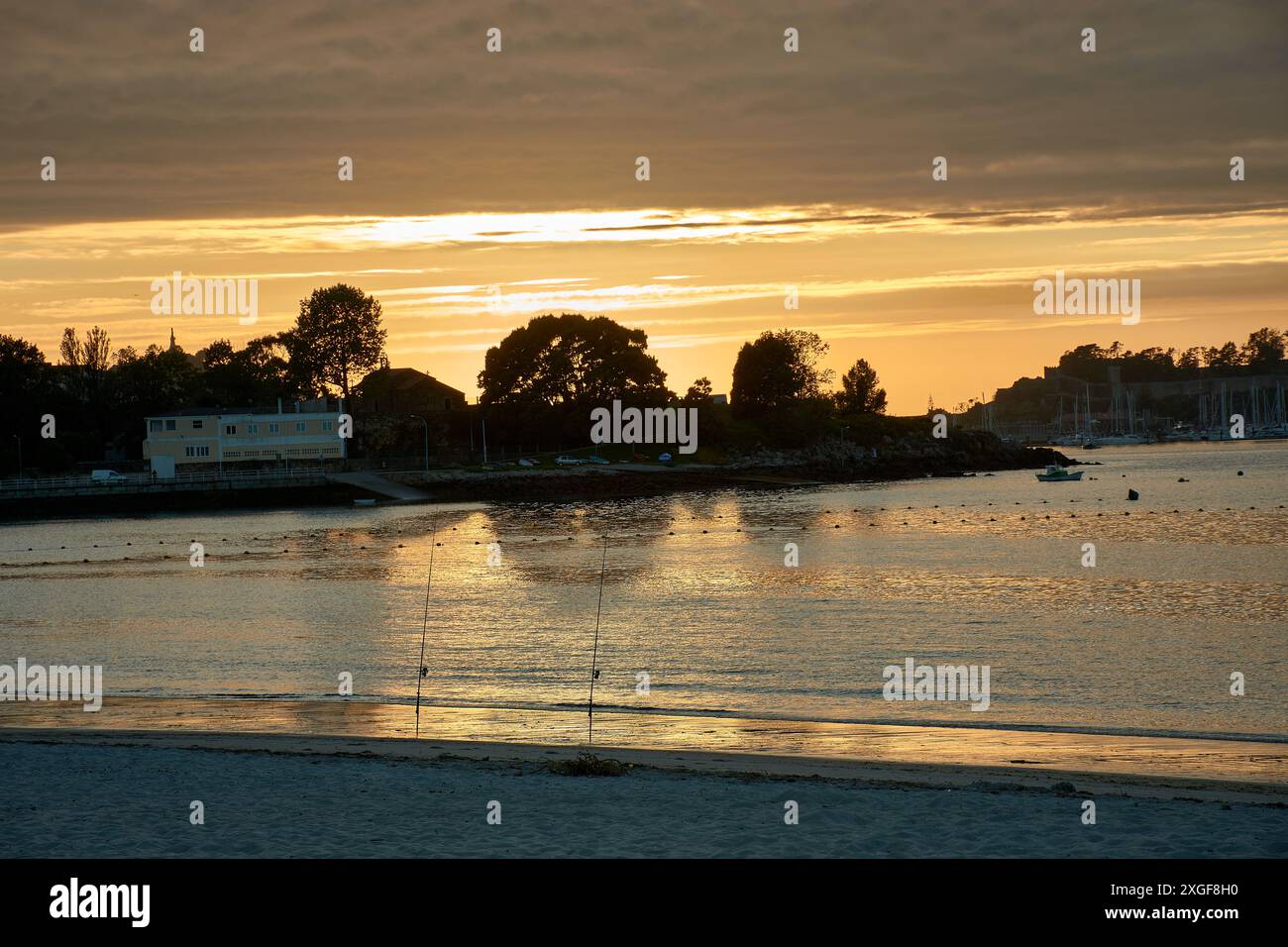 Ein wunderschöner Sonnenuntergang zeigt den Himmel über dem Strand von Ladeira in Sabaris, während ein einsamer Fischer an der Küste arbeitet. Das goldene Licht der untergehenden Sonne erstrahlt Stockfoto