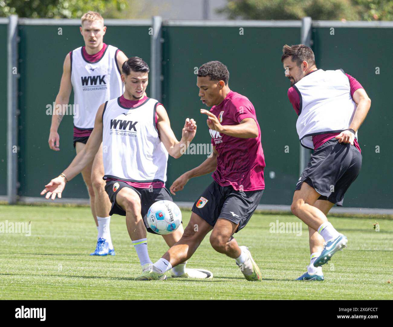 Kampf um den Ball zwischen Yusuf Kabadayi (FC Augsburg, li.) und Henri Koudossou, David Colina (re.); FC Augsburg, Training, Stockfoto