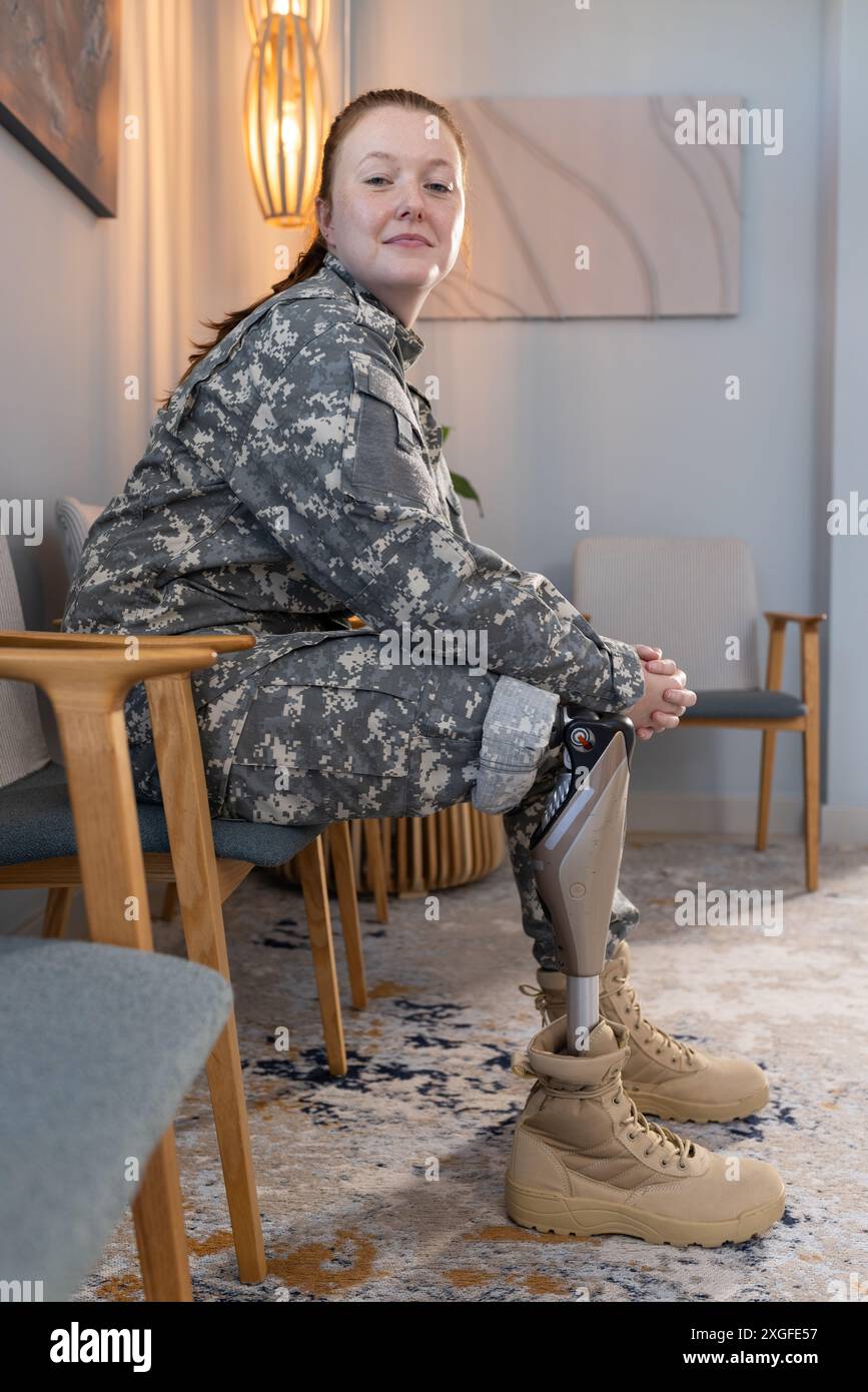 Undefinierte Uniform tragen, Frau mit prothetischem Bein im Wartebereich Stockfoto