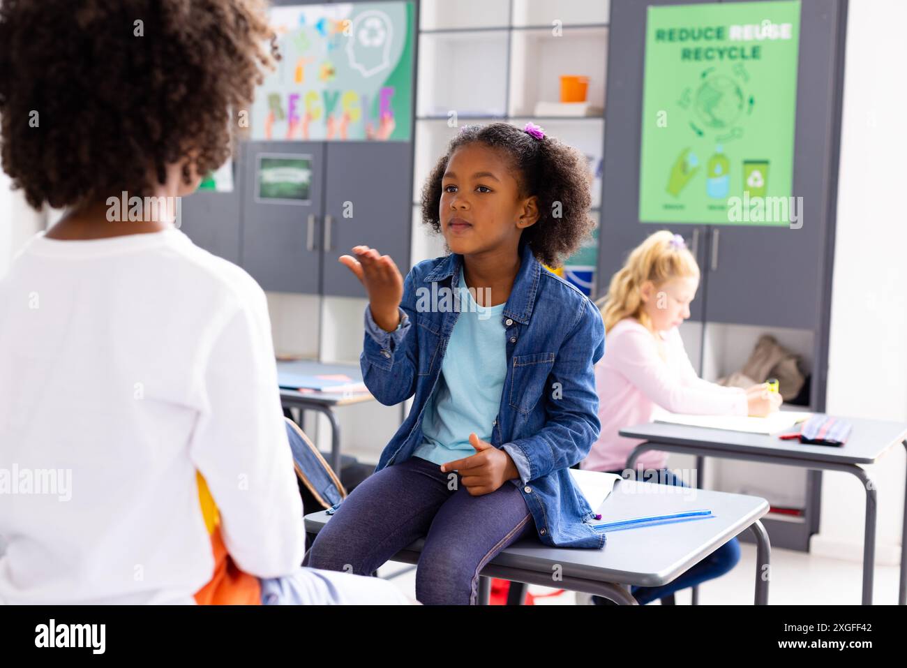 Glückliche, vielfältige Schulkinder, die Gebärdensprache im Schulunterricht benutzen Stockfoto