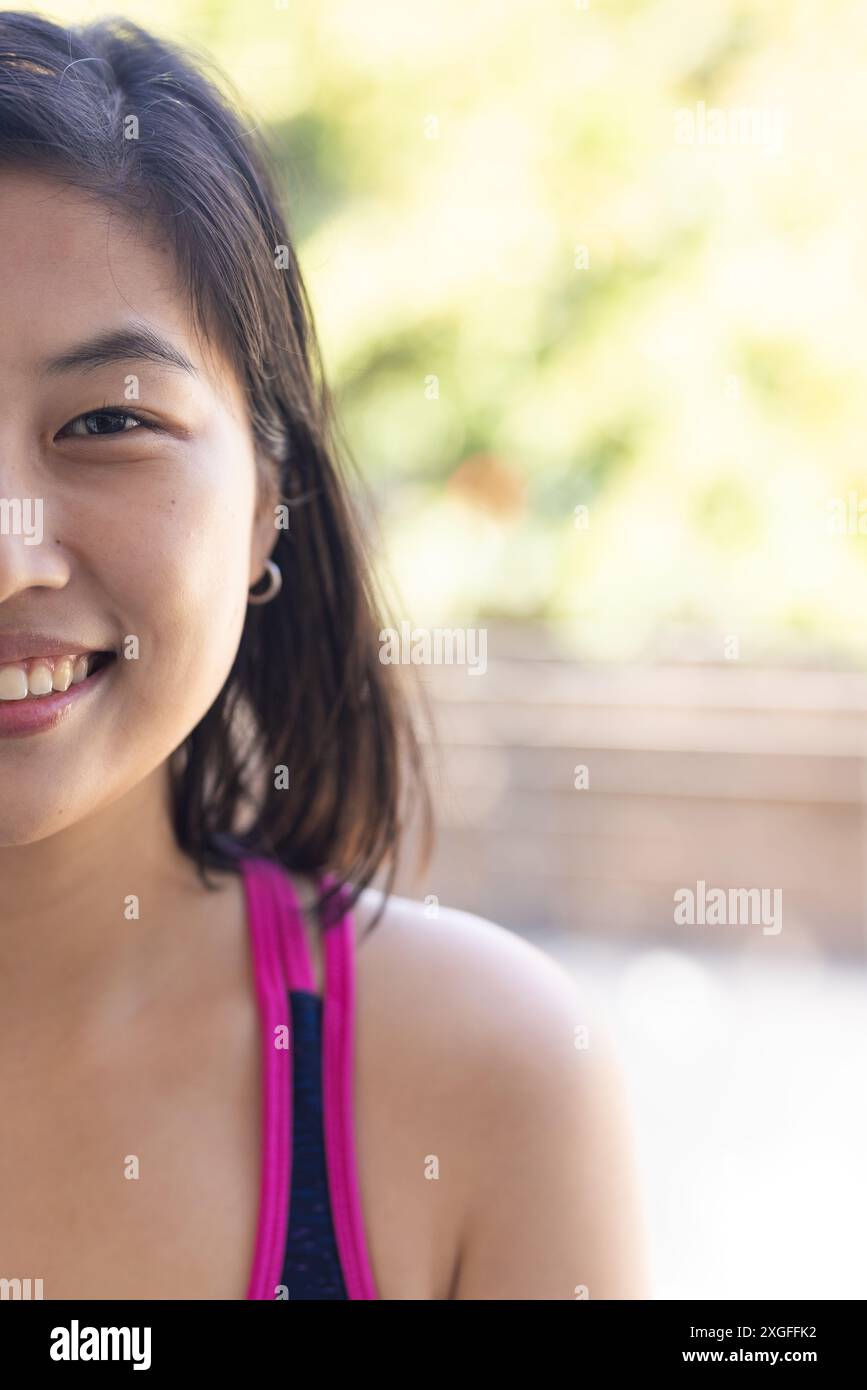 Lächelnde Frau in legeren Kleidern, die zu Hause im Freien ihre Zeit genießt Stockfoto