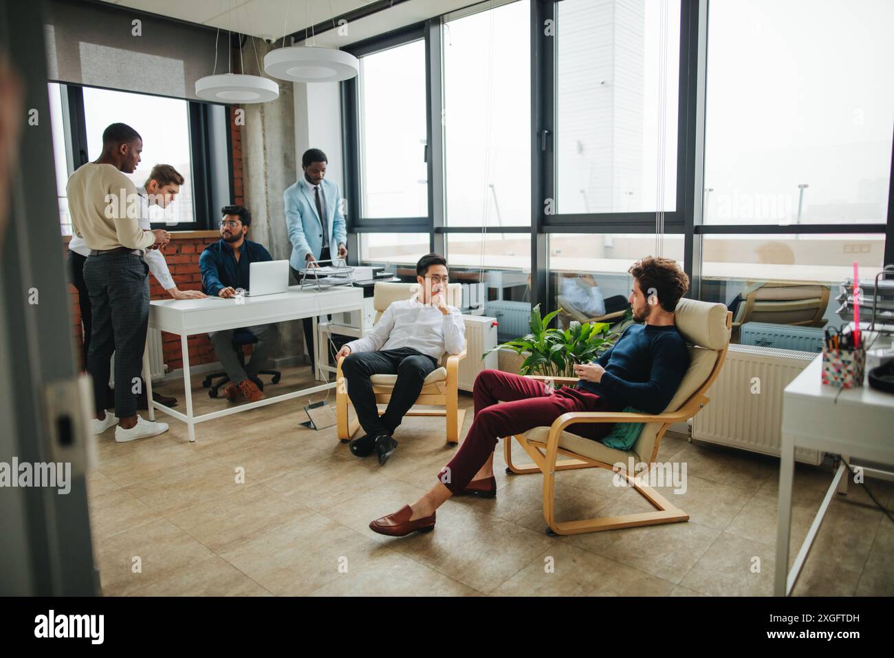 Gemischte Rasse Mitarbeiter Rest nach Essen, Relaxen im Büro Lounge Zone, gemeinsame Themen zu diskutieren. Stockfoto