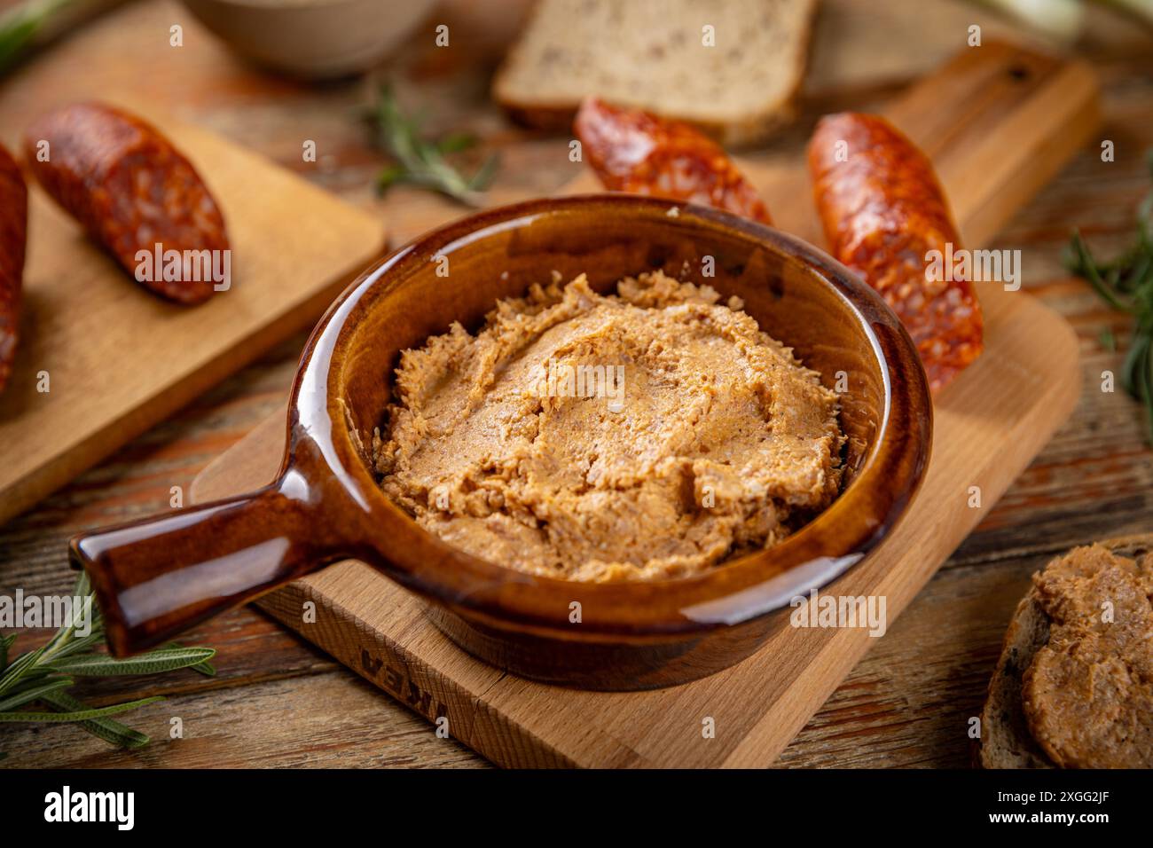 Köstliche hausgemachte Würstchen mit Gewürzen und Paprikawurst auf Holzbrett Stockfoto