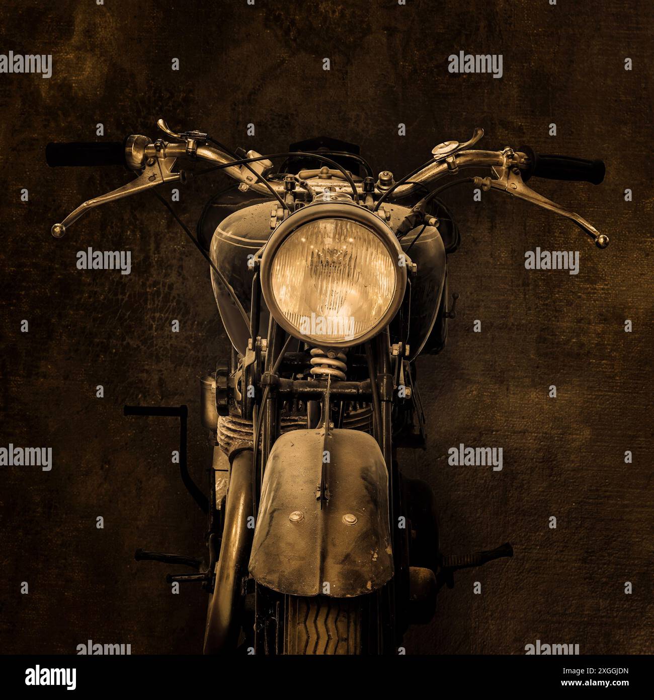 Vorderansicht eines englischen Vintage-Motorrads vor dunklem Hintergrund Stockfoto