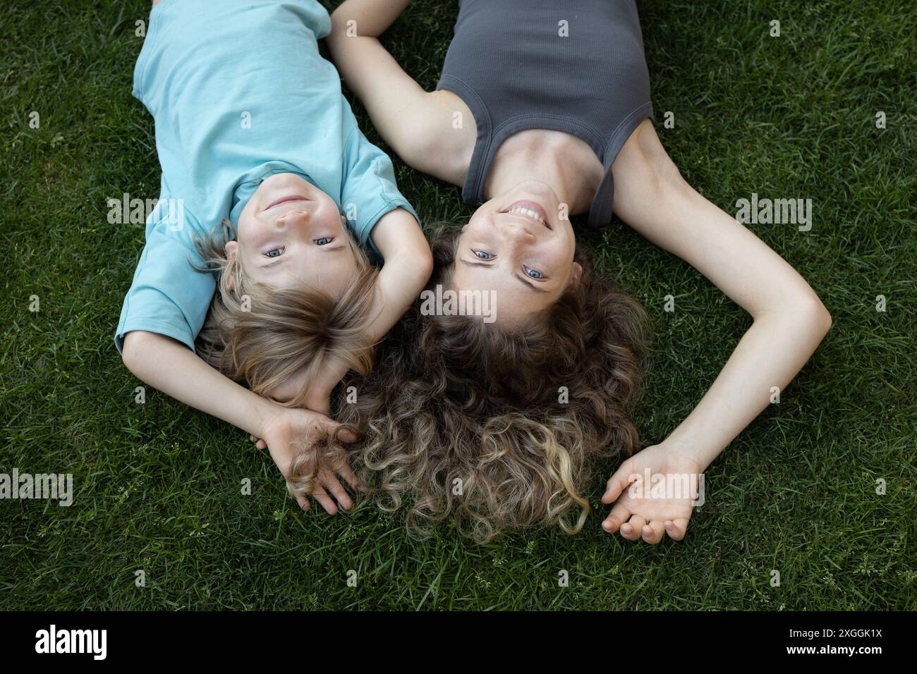 Kinder unterschiedlichen Alters, Bruder und Schwester liegen auf dem Gras und schauen in die Kamera. Freundliche, fröhliche Familie. Sommerferien, Ferien, Spaß Stockfoto