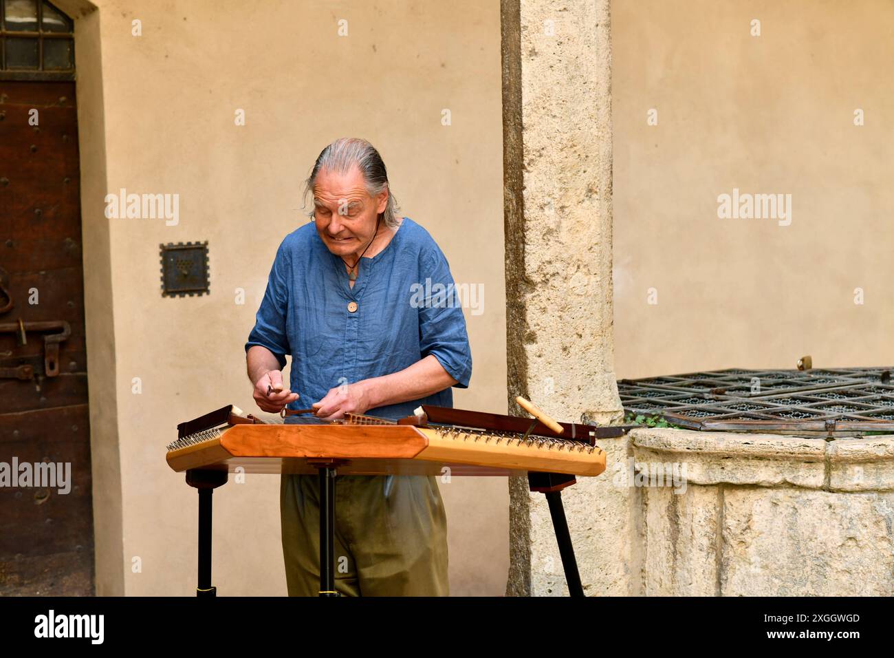 San Gimignano in der Toskana, Italien, Musiker spielen historische Instrumente Harfe und Xylofon im Innenhof des Palazzo del Popolo Stockfoto