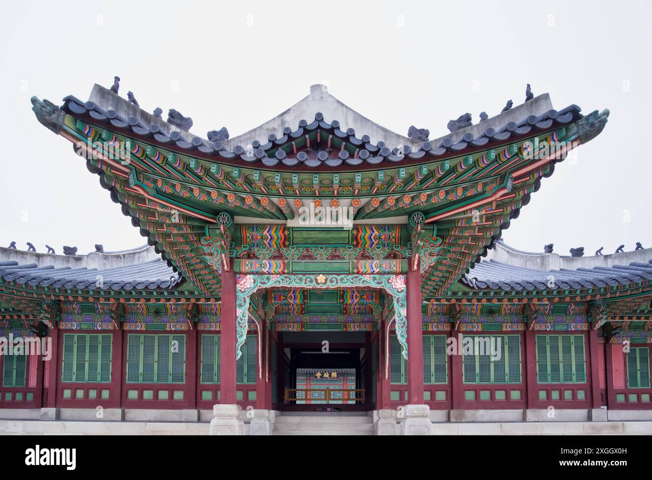 Reich verzierter Eingang zum koreanischen Palast mit leuchtender grüner und roter Farbe, die die komplizierte traditionelle Architektur zeigt Stockfoto