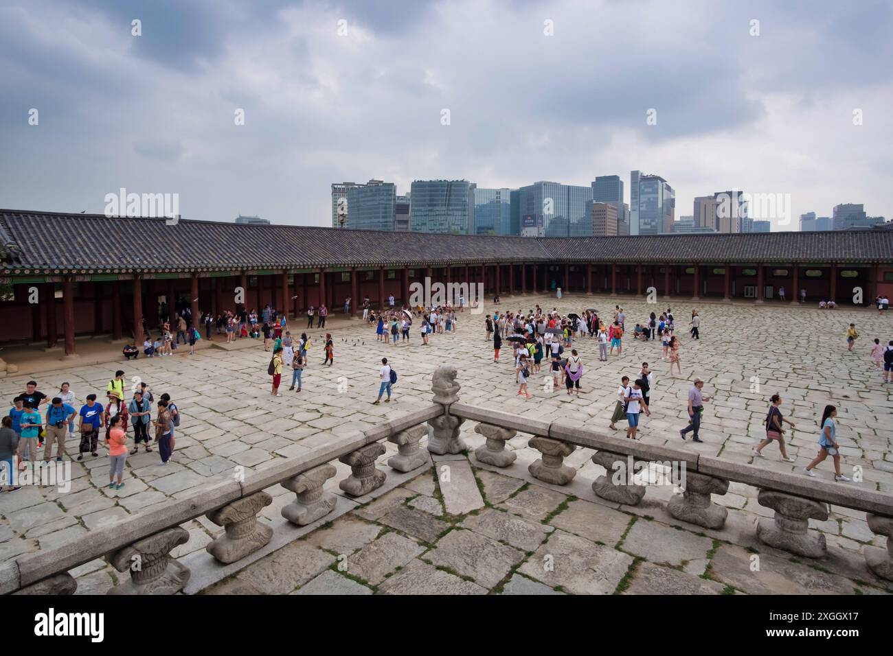 Der historische koreanische Palast im Innenhof voller Touristen, die moderne Skyline von Seoul ist jenseits der traditionellen Architektur sichtbar. Stockfoto