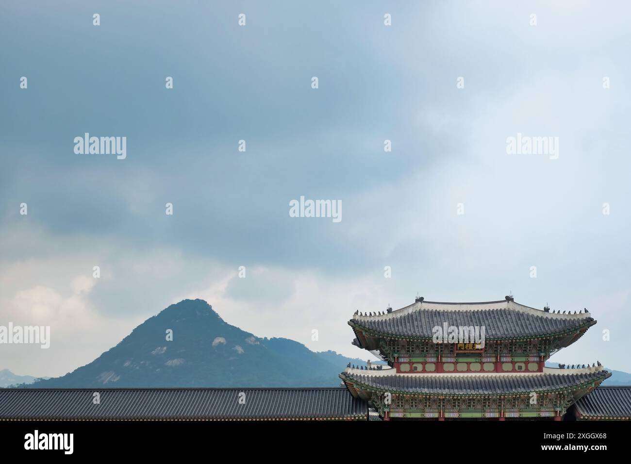 Traditionelles koreanisches Palastdach mit Bergkulisse und kunstvoller Architektur vor natürlicher Landschaft Stockfoto