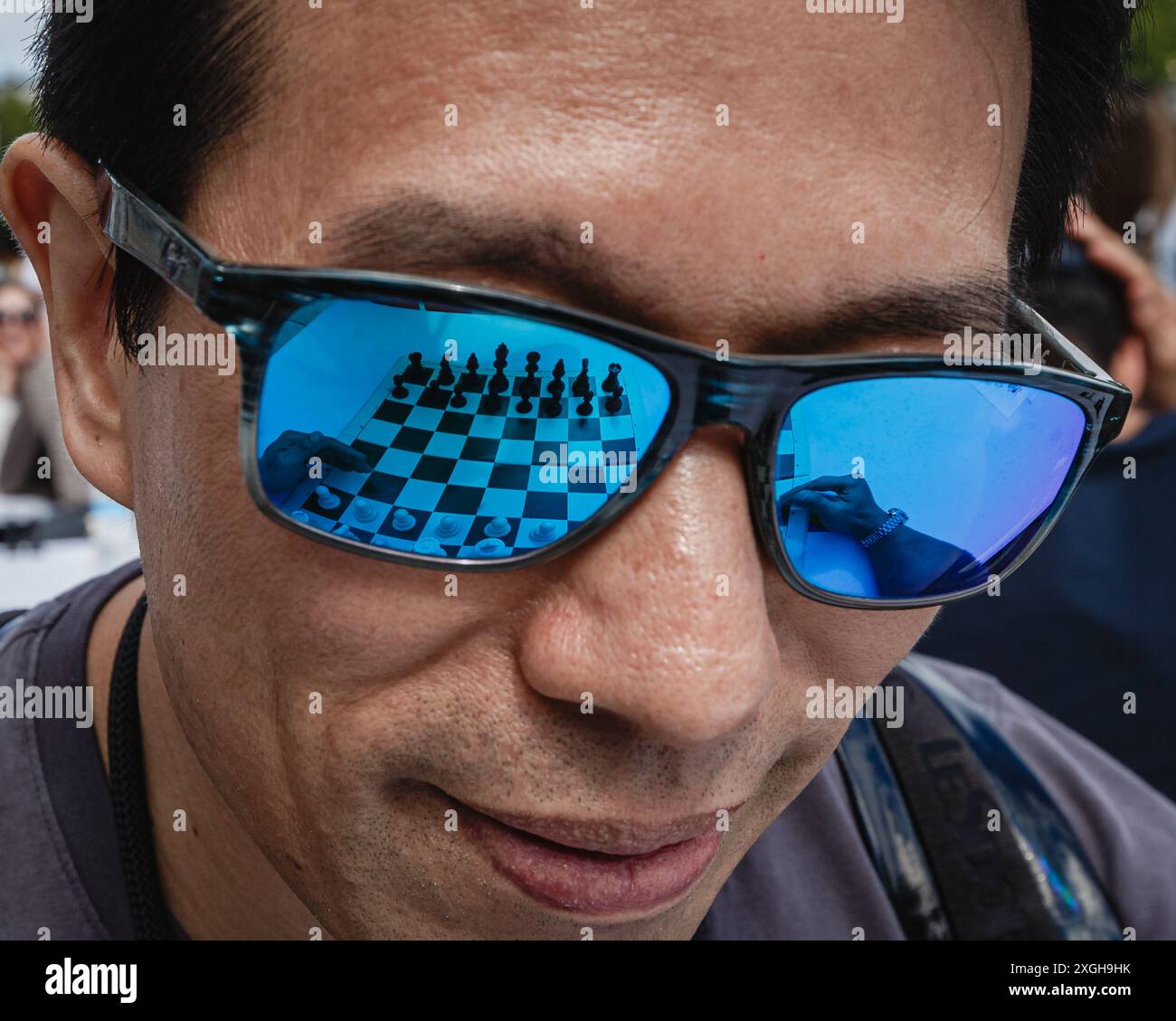 Ein Schachbrett, das sich in der Sonnenbrille eines Spielers spiegelt. Stockfoto
