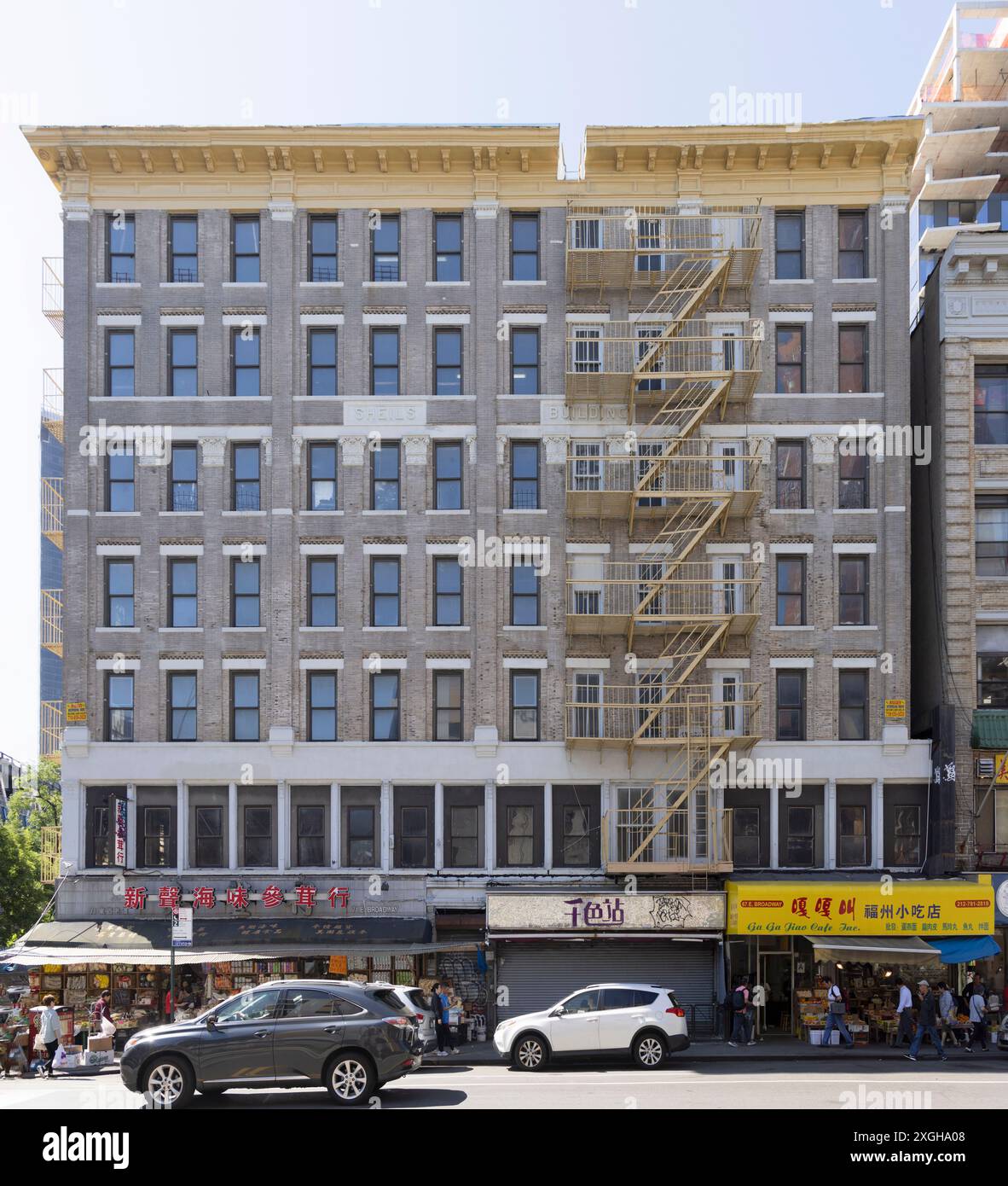 NYC Chinatown: Sheils Building, 67-73 East Broadway, ist ein siebenstöckiges Backsteingebäude mit Geschäften und Büros in den ersten beiden Stockwerken. Stockfoto