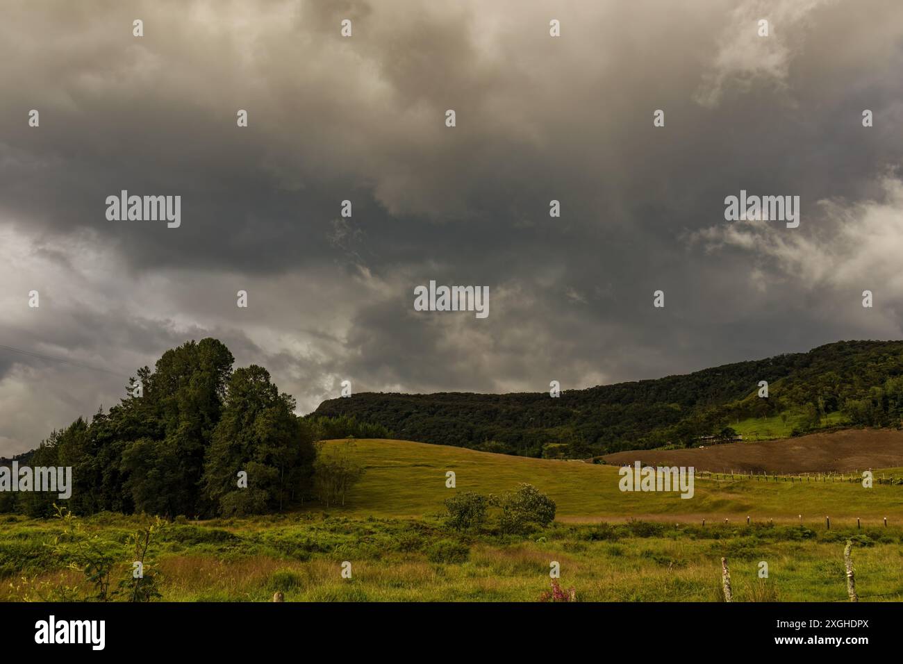 Niedrige Wolken, die an einem bewölkten Nachmittag in der Nähe der Stadt Arcabuco über den Bergen in den östlichen Anden Kolumbiens schweben. Stockfoto