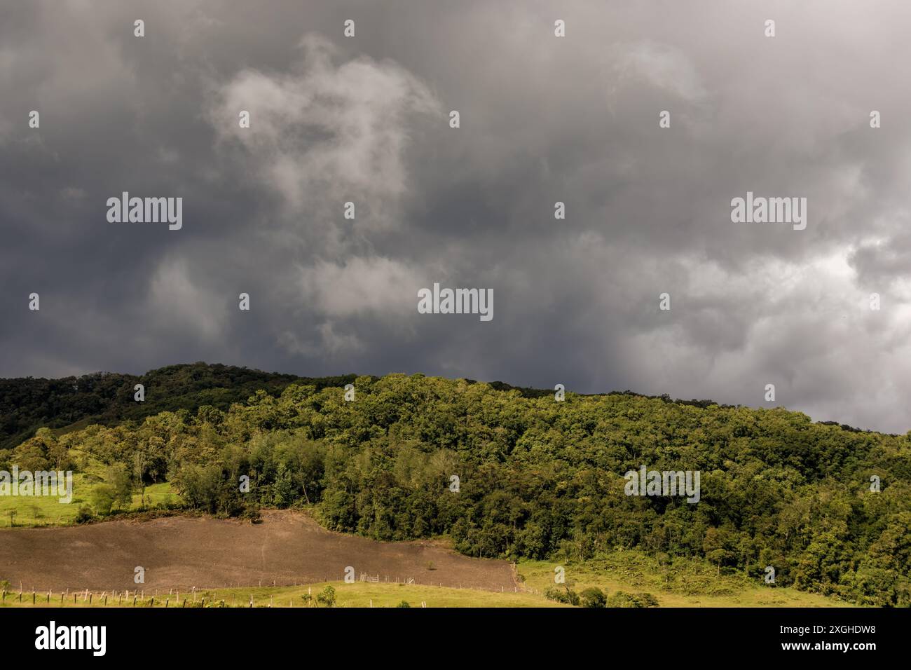 Niedrige Wolken, die an einem bewölkten Nachmittag in der Nähe der Stadt Arcabuco über den Bergen in den östlichen Anden Kolumbiens schweben. Stockfoto