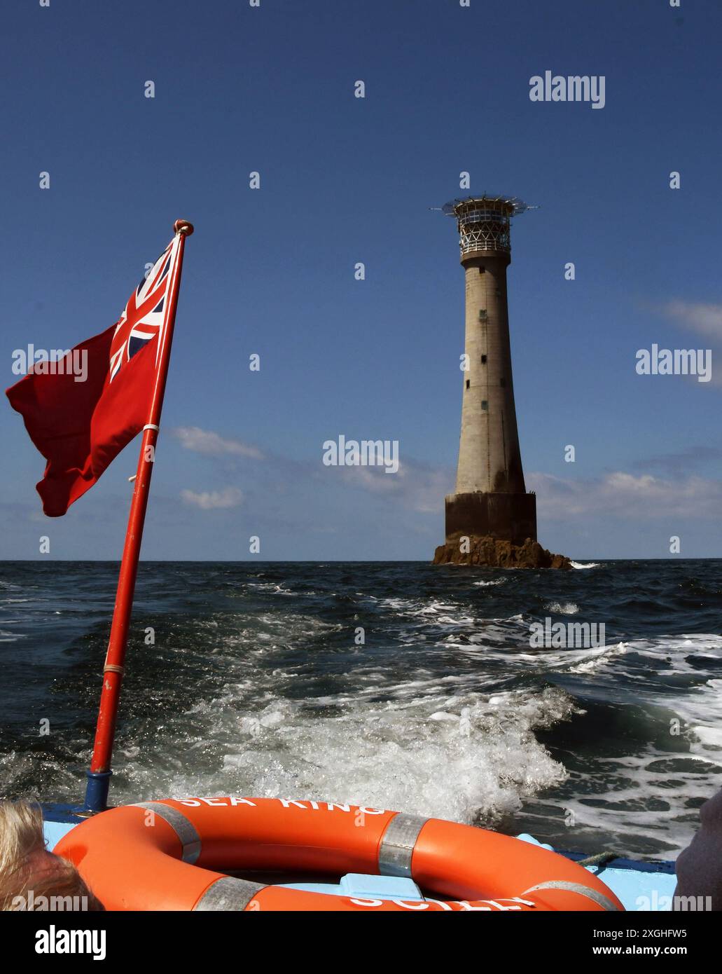 Touristenboot, das vom Bishop Rock Lighthouse zurückkehrt, das 1858 von Trinity House erbaut und 1887 verstärkt wurde und sich vier Meilen wes befand Stockfoto