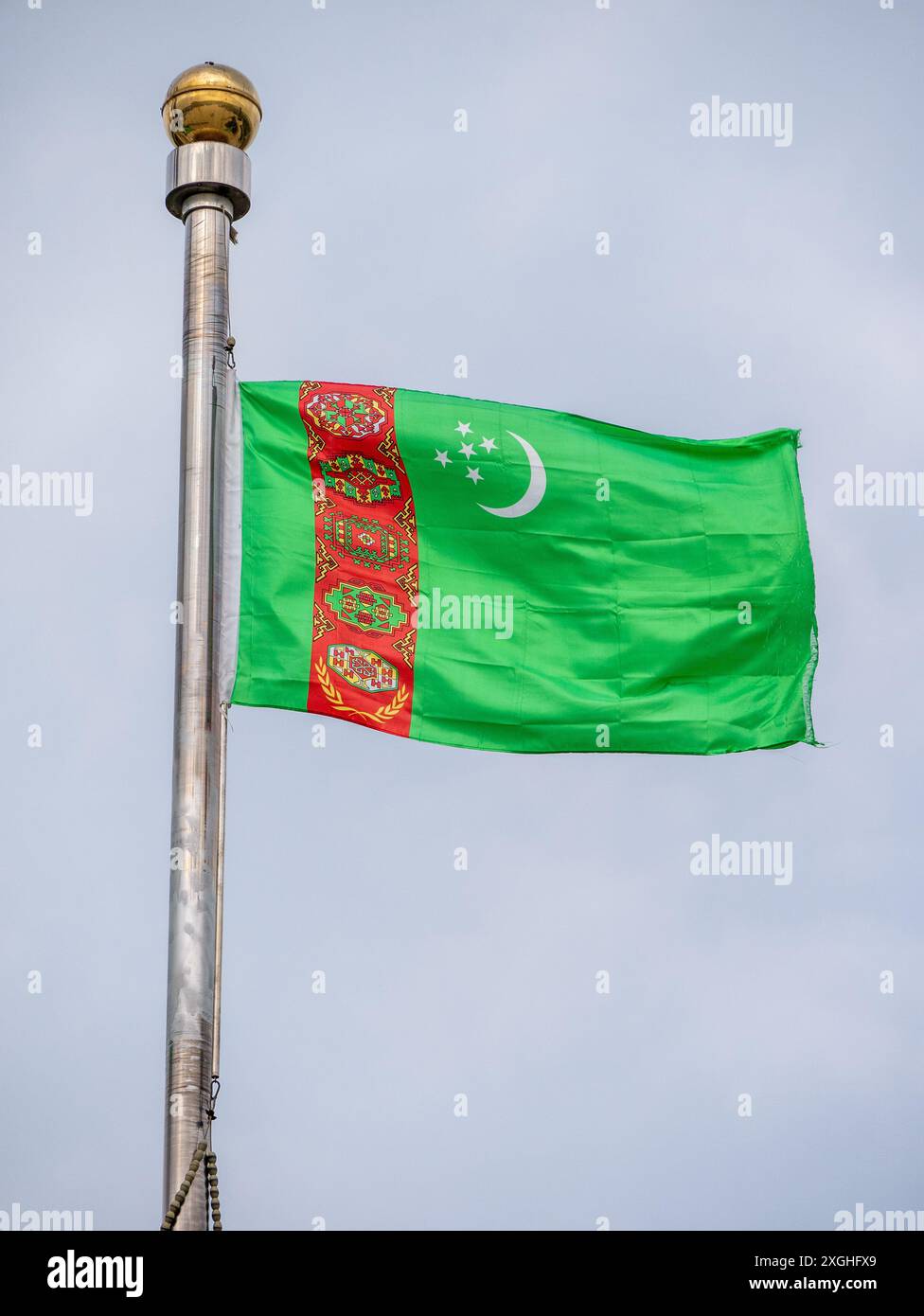 Turkmenische Flagge fliegt an einem bewölkten Nachmittag im Halk Hakydasy Memorial Complex Stockfoto