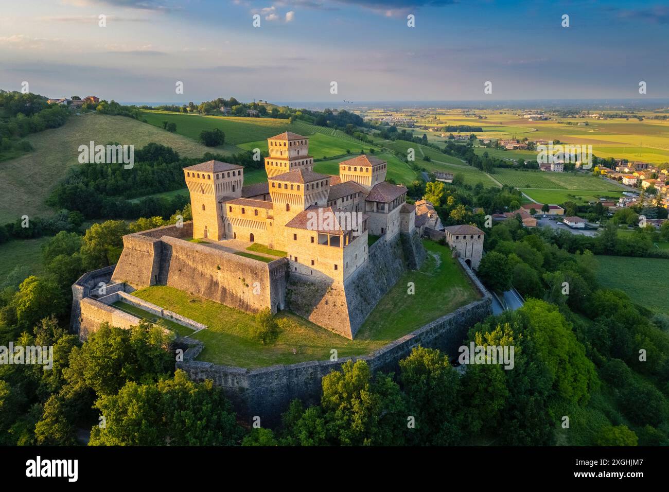 Aus der Vogelperspektive auf das Schloss von Torrechiara während eines Sommersonnenverganges. Langhirano, Provinz Parma, Emilia Romagna, Italien, Europa. Stockfoto