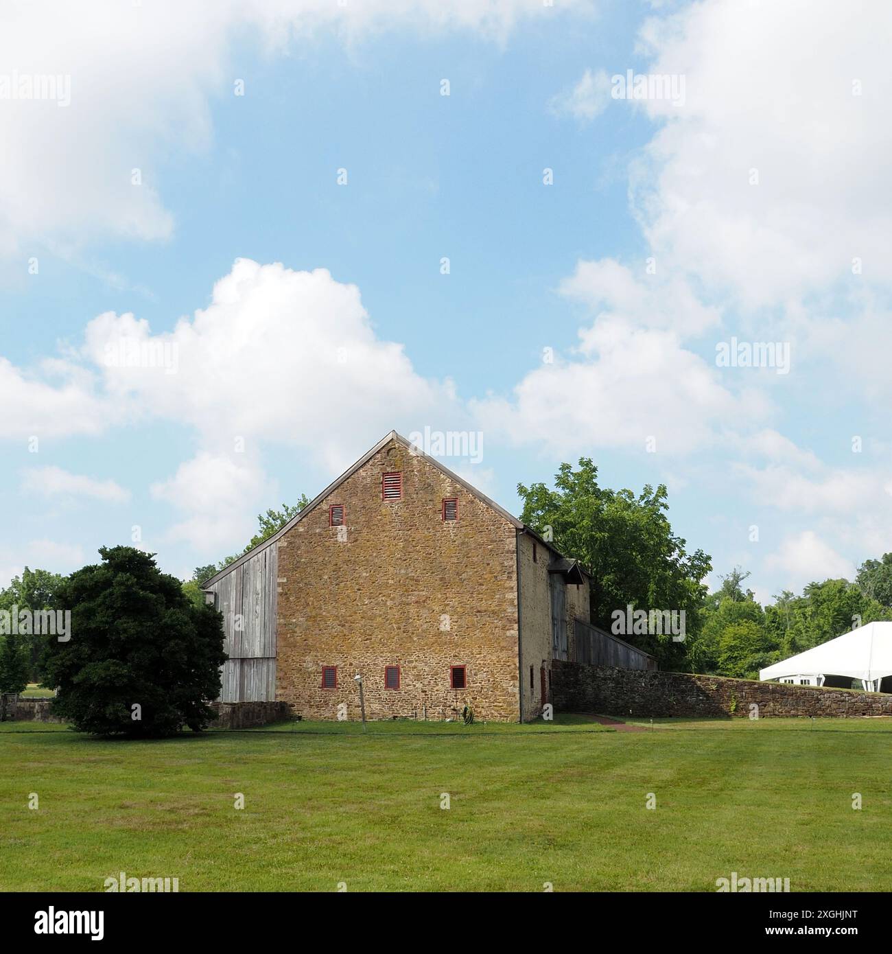 Die Farm hat eine sehr alte Scheune im Hintergrund. Stockfoto