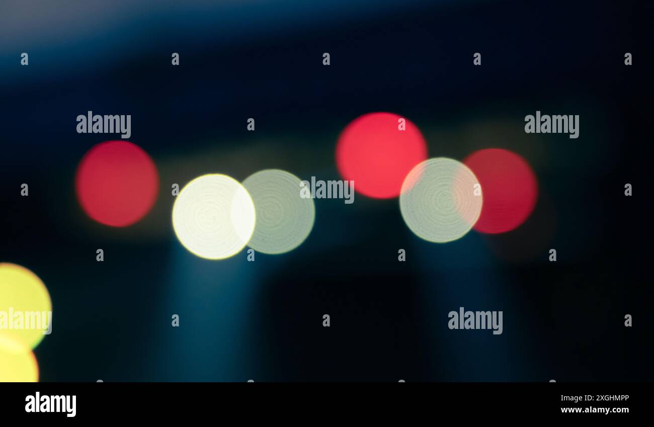 Farbenfrohe, unscharfe Lichtflecken auf blauem schwarzem Hintergrund, abstraktes Foto. Bokeh ist ein natürlicher optischer Effekt Stockfoto Farbenfrohe, unscharfe Lichtflecken auf blauem schwarzem Hintergrund, abstraktes Foto. Bokeh ist ein natürlicher optischer Effekt Stockfoto