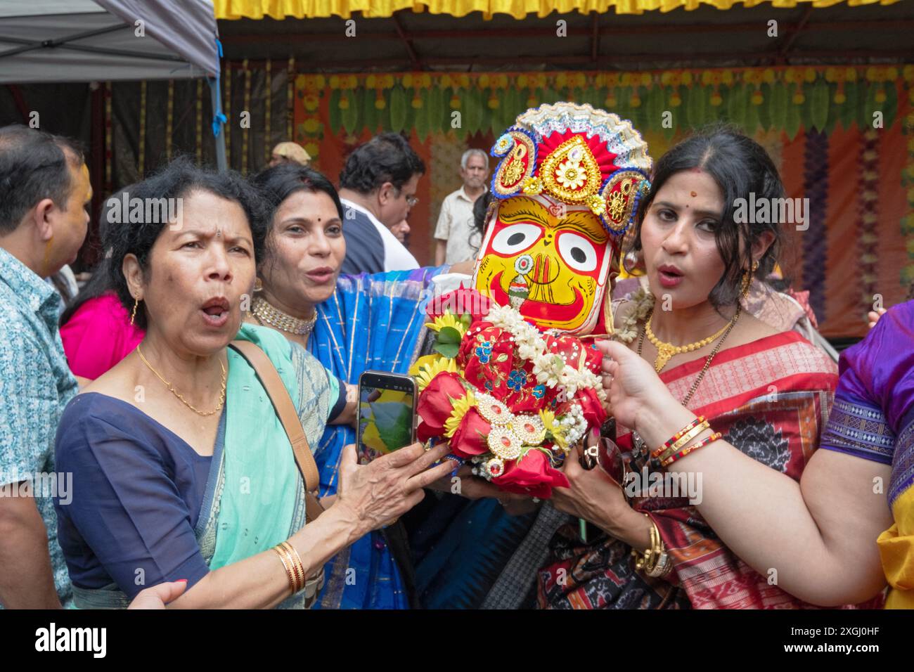 Hindu-Frauen tragen eine Statue von Subhadra zum Wagen, wo sie für das Ratha Yatra 2024 in Wilton, Connecticut, aufgestellt wird. Stockfoto Hindu-Frauen tragen eine Statue von Subhadra zum Wagen, wo sie für das Ratha Yatra 2024 in Wilton, Connecticut, aufgestellt wird. Stockfoto