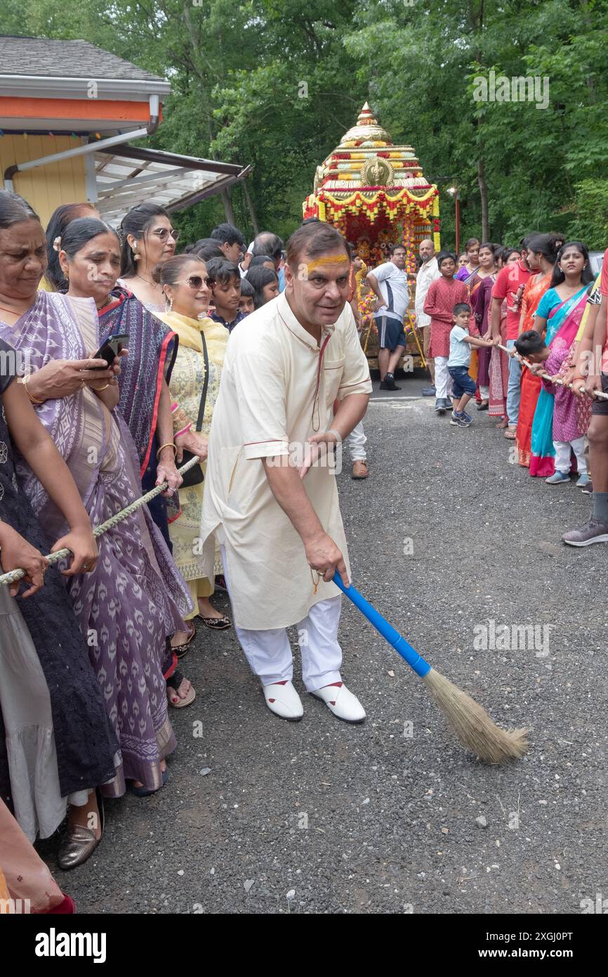 Vor dem Beginn des Ratha Yatra 2024 begibt sich ein hinduistischer Anhänger auf dem Weg, den der Wagen während der Prozession durchqueren wird. In Wilton Connecticut. Stockfoto