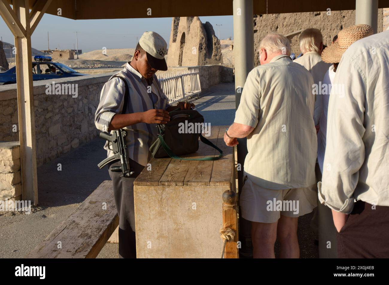 Sicherheitsbeamter mit Maschinenpistole Heckler & Koch MP5-K durchsucht die Taschen von Touristen am Eingang von Deir el-Bahari in der Nähe von Luxor, Ägypten Stockfoto
