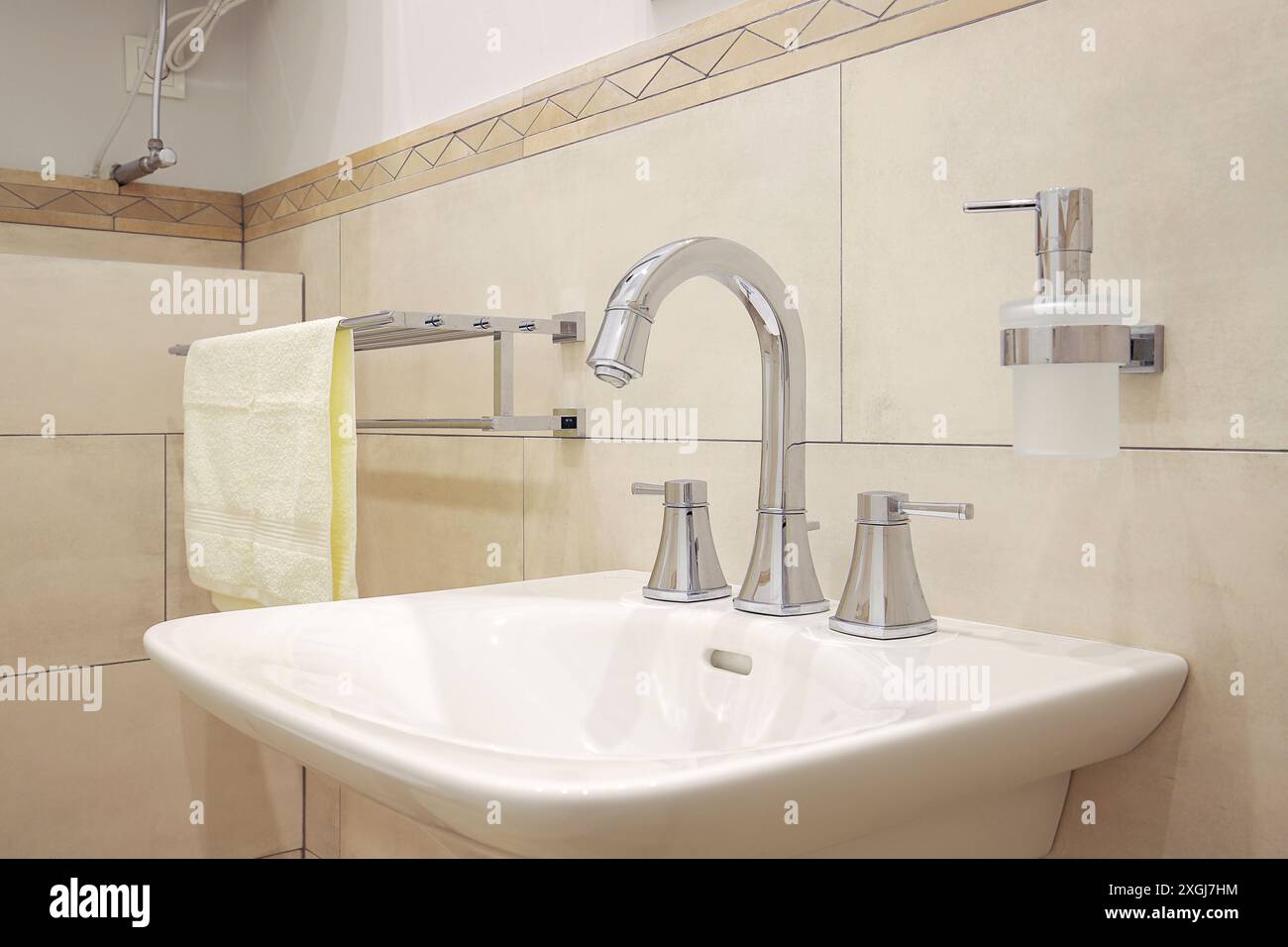 Chrom-Wasserhahn mit weißem Keramikwaschbecken im Badezimmer Stockfoto