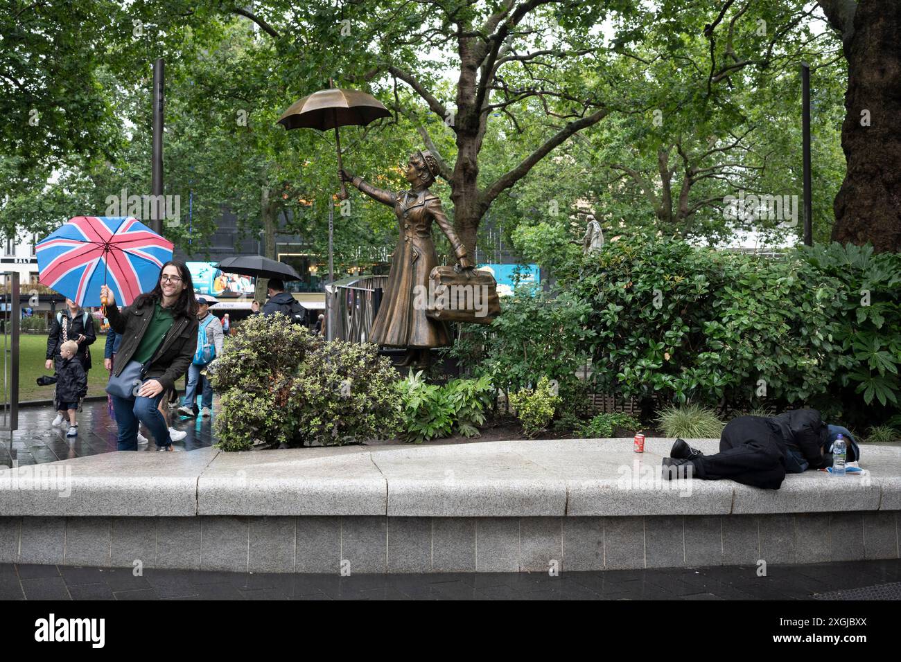 Besucher der Hauptstadt können die Statue von Mary Poppins auf dem Leicester Square im West End am 9. Juli 2024 in London, England, besuchen. In vielen Teilen des Vereinigten Königreichs war bereits an den ersten sieben Tagen des Monats ein durchschnittlicher monatlicher Niederschlag von 66 cm zu verzeichnen - 139 % der für den gesamten Juli erwarteten Gesamtmenge. (Foto von Richard Baker / in Bildern über Getty Images) Stockfoto