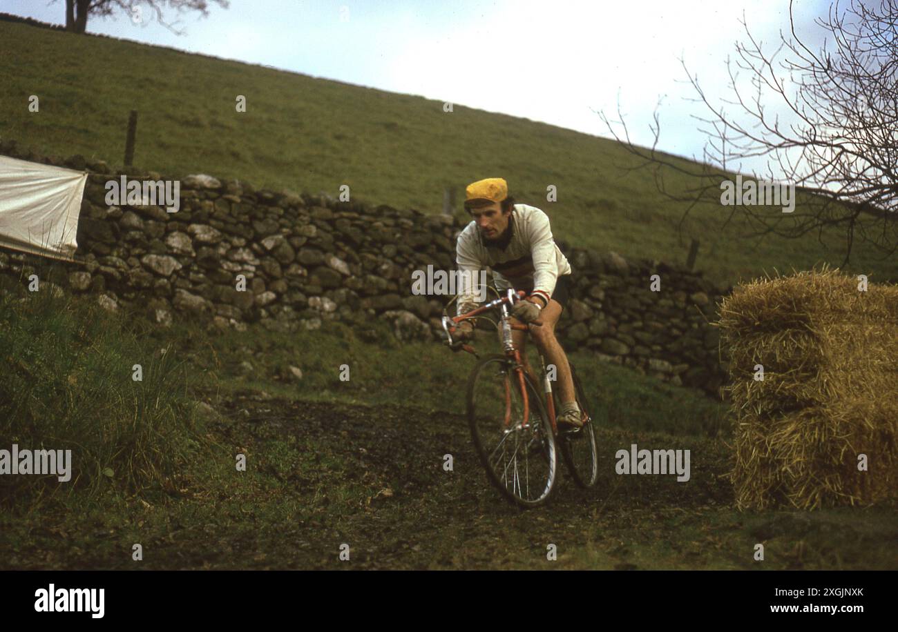 1970er Jahre, historisch, ein männlicher Konkurrent bei einem Radkreuz-Rennen, England, Großbritannien. Radfahren ist eine Radsportart, bei der die Fahrer sich mit natürlichem Gelände auseinandersetzen und über Landschaft, Felder, Hügel und Hindernisse fahren, wobei sie oft absteigen und ihr Fahrrad tragen müssen. Die Rennen finden traditionell im Herbst und Winter statt. Stockfoto